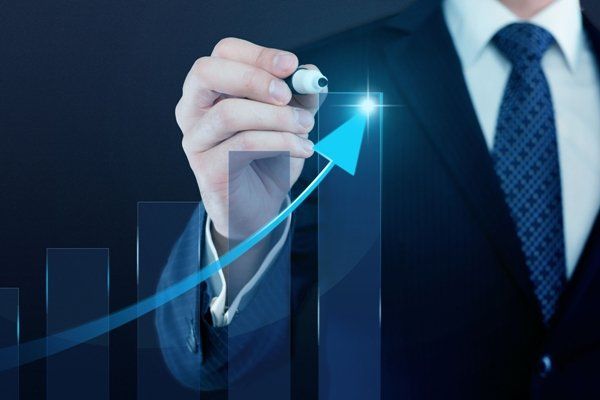 גבר בחליפה ועניבה מצייר גרף עם טוש.