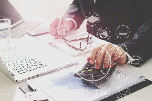 אדם יושב ליד שולחן באמצעות מחשבון.