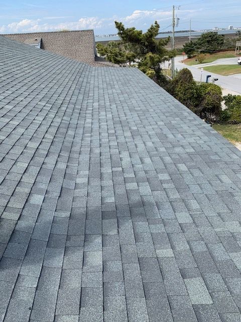 Gray asphalt shingle roof on a sunny day.