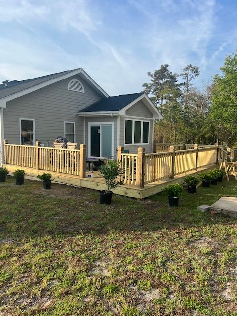 Wooden steps and landing lead up to a mobile home's side entrance; a car is parked nearby.