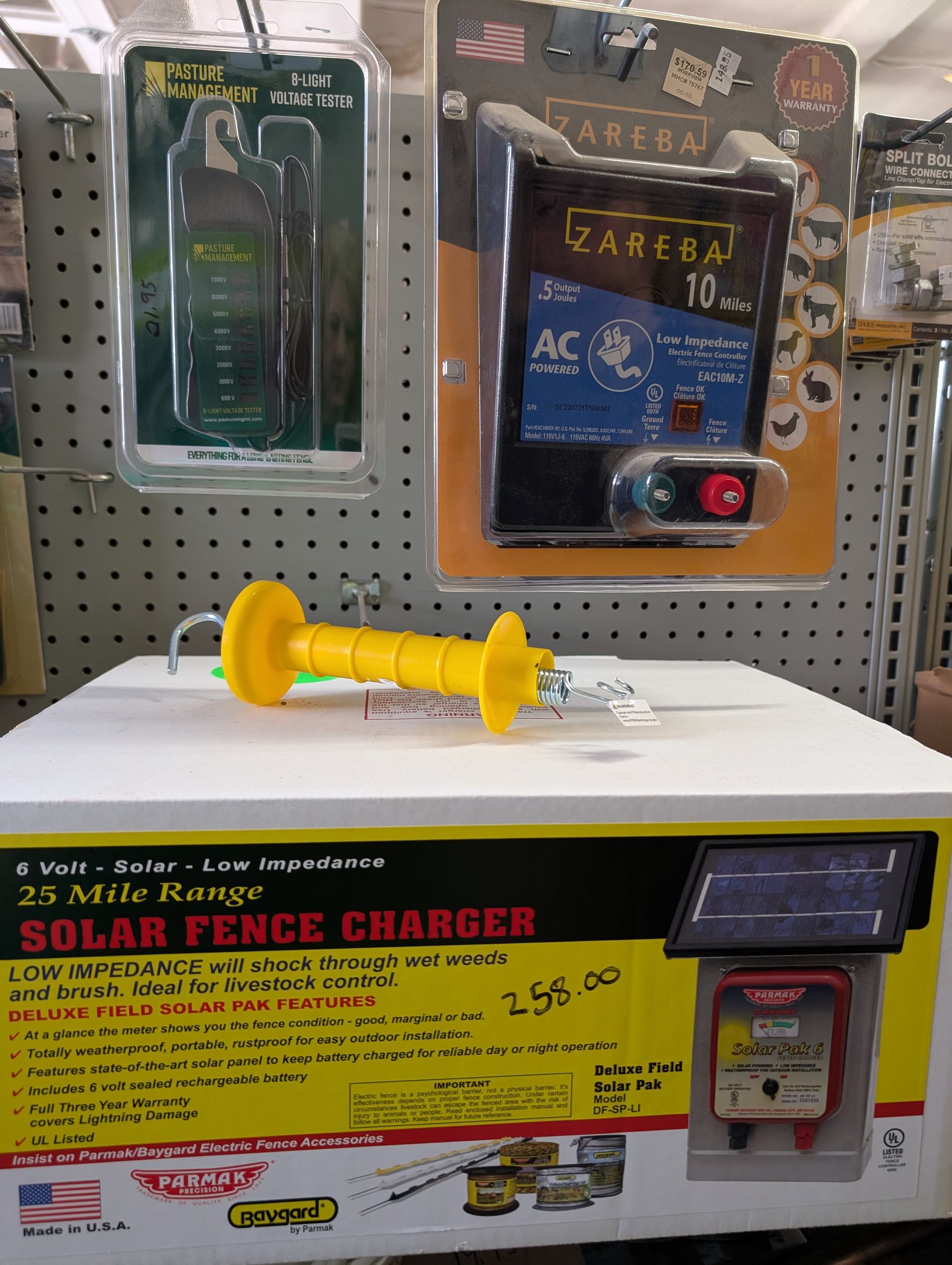 A bunch of potted plants are sitting on pallets outside of a store.