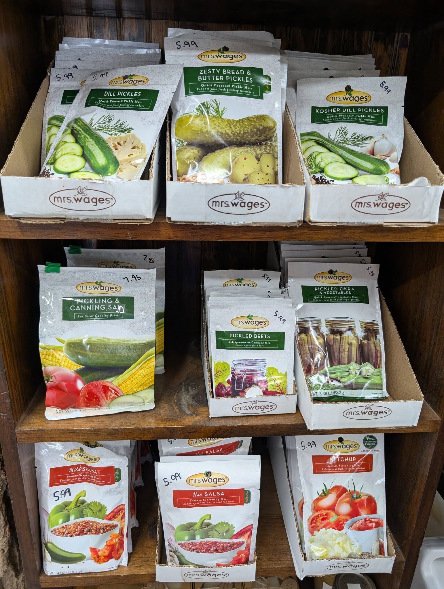 A wooden shelf filled with boxes of vegetable seeds.