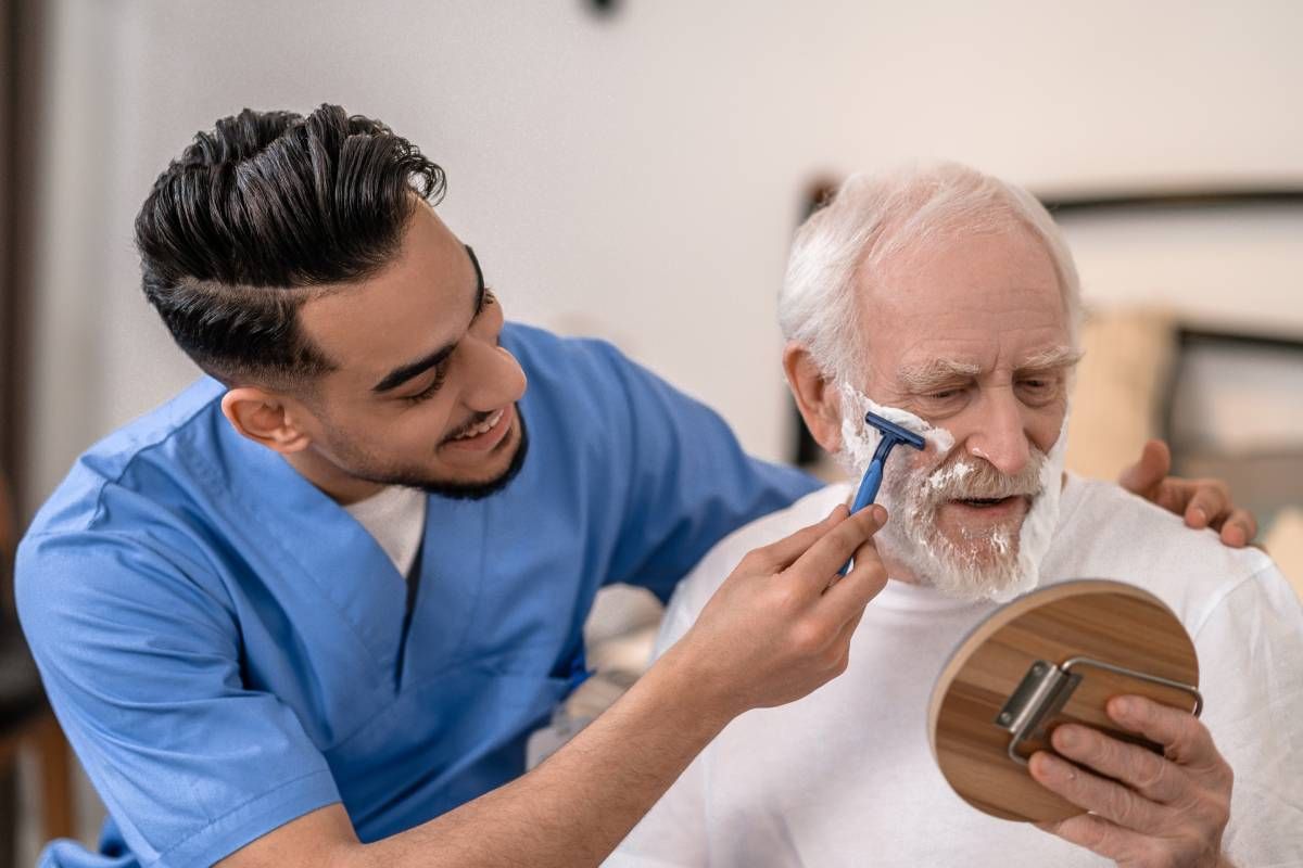 A caregiver helping someone shave within their own home near Lexington, Kentucky