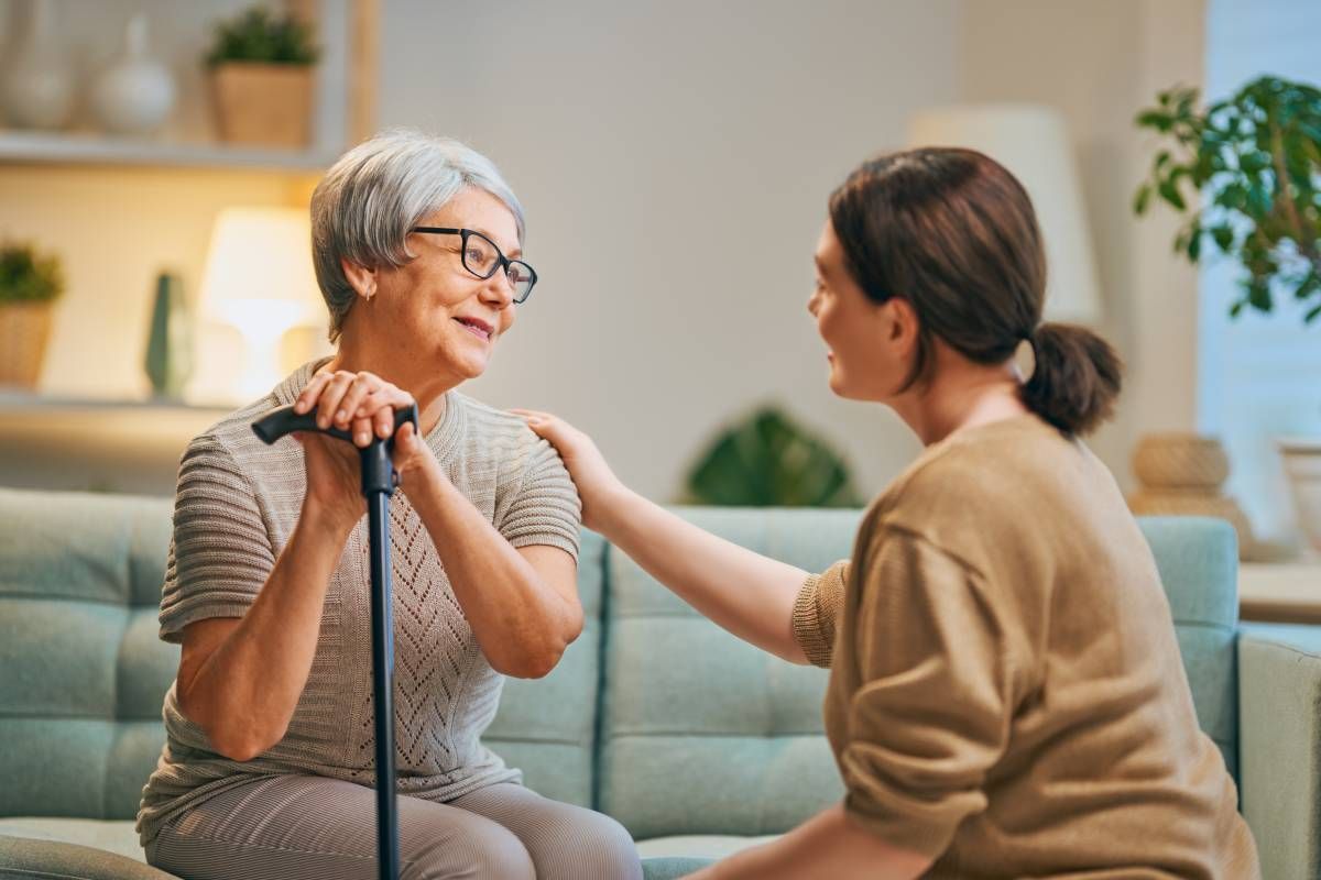 A senior and a caregiver having a conversation in the living room near Lexington, Kentucky