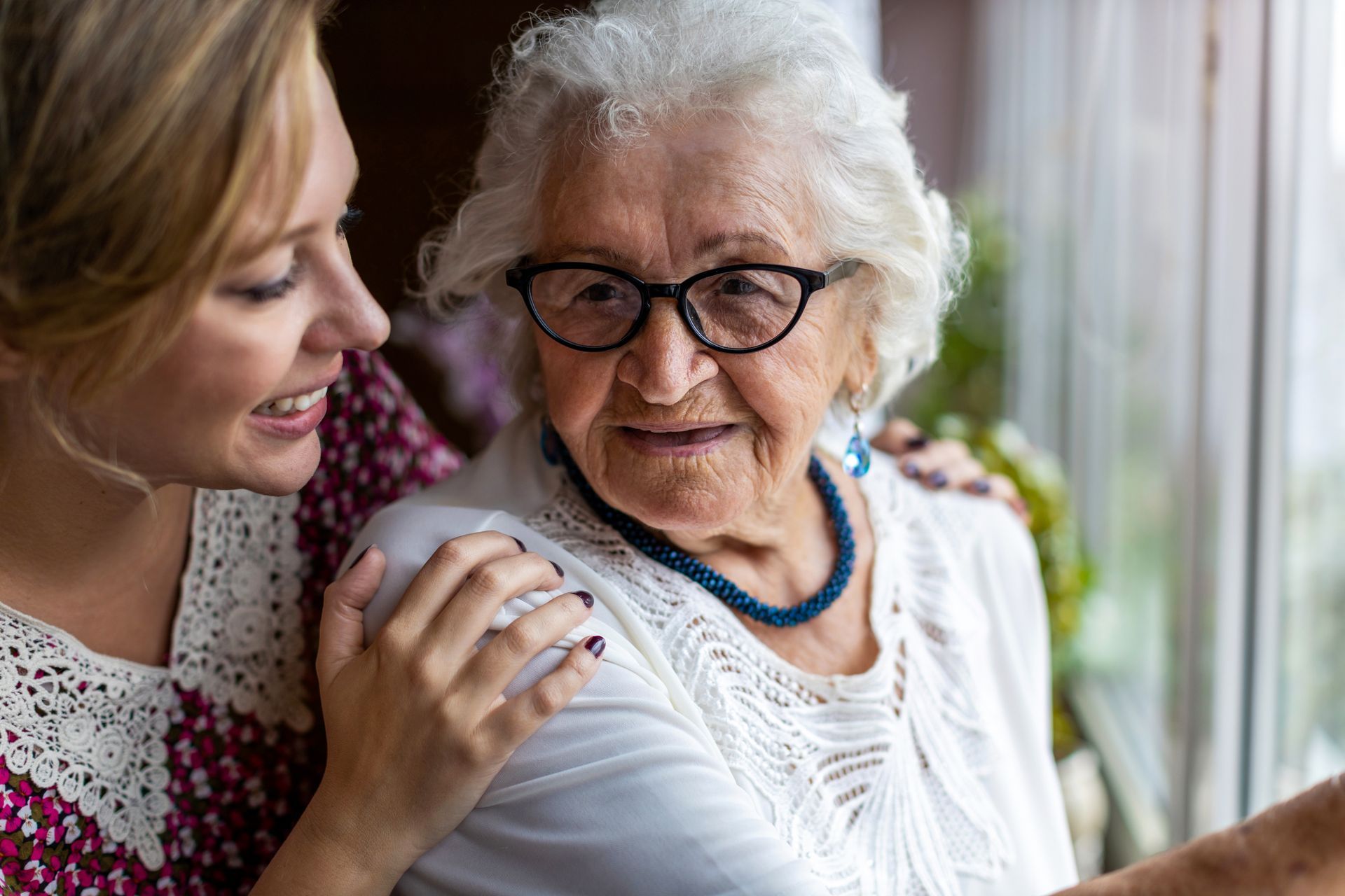 A young woman and caregiver spending time with their grandmother