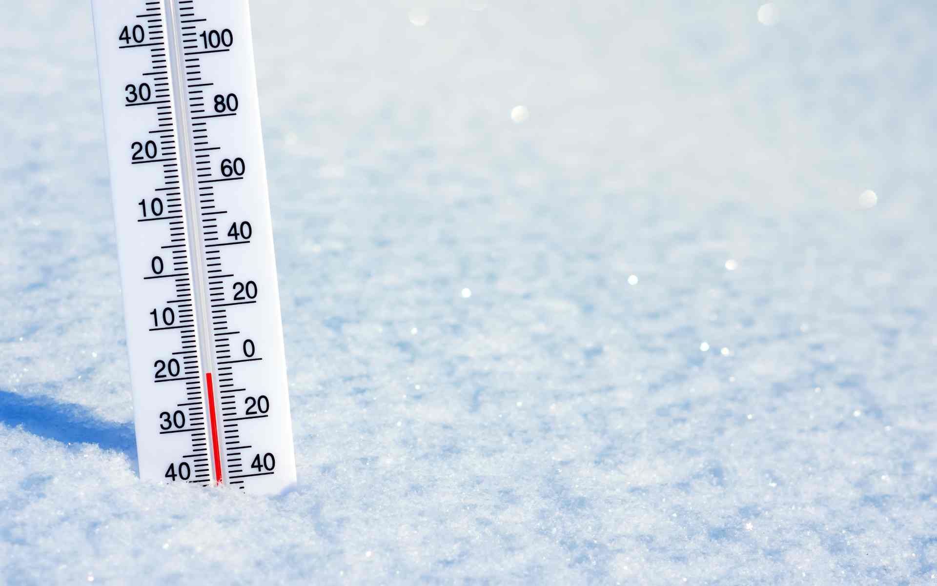 A thermometer partially buried in the snow, showing below-freezing temperatures near Lexington, Kent