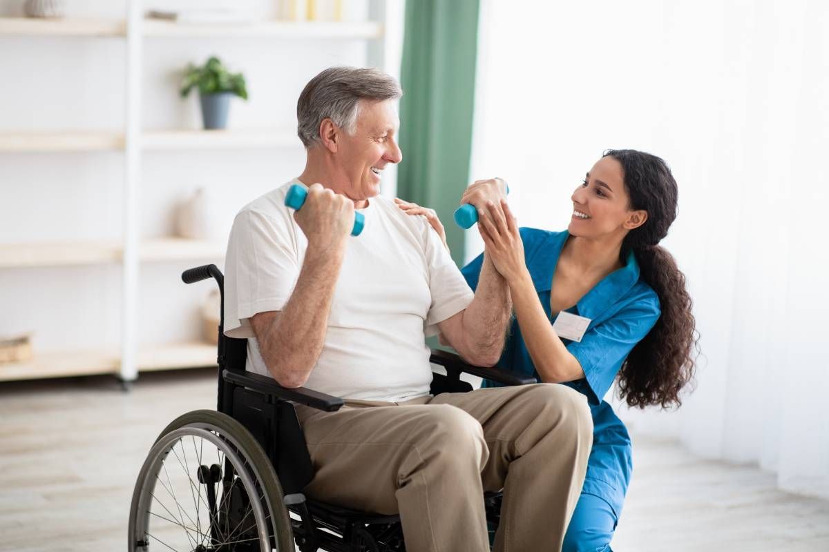 A caregiver helping a senior use dumbells to work on upper body strength at Family Choice Home Care near Lexington, Kentucky