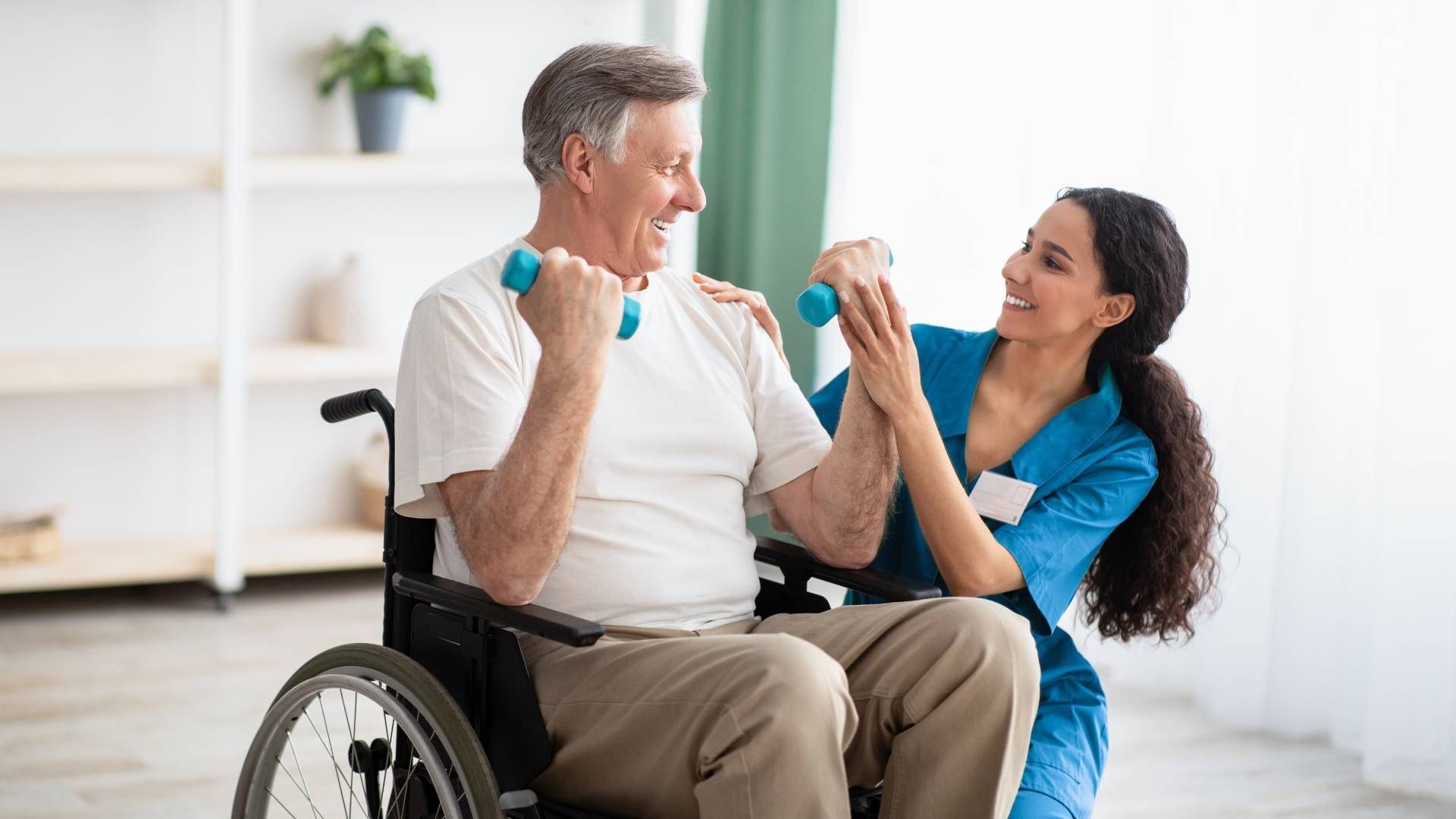 A caregiver helping a senior use dumbells to work on upper body strength at Family Choice Home Care 