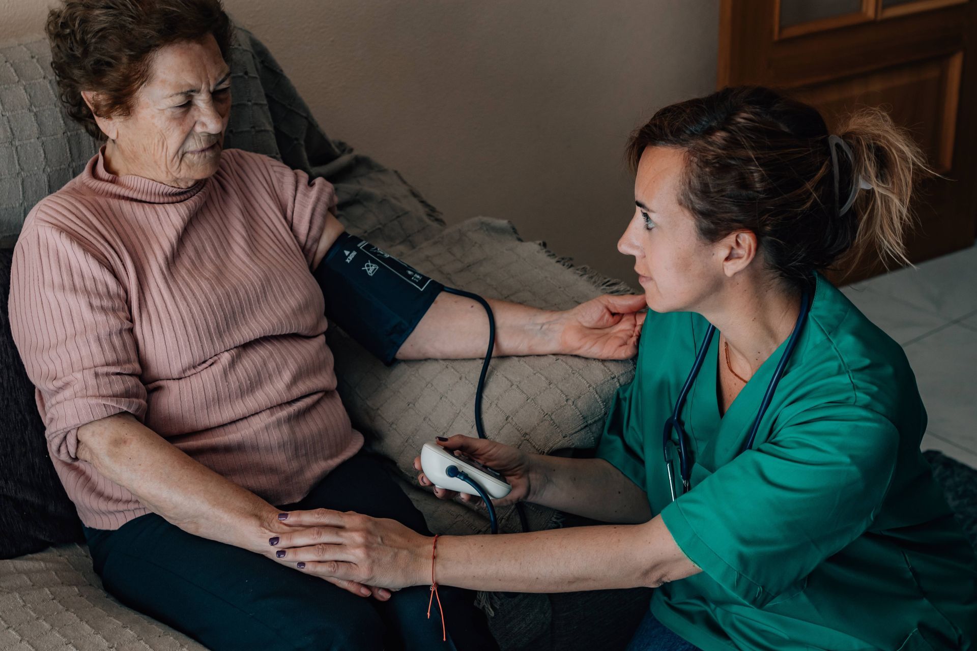 A professional caregiver working with a senior in their home representing an in-home care structure.