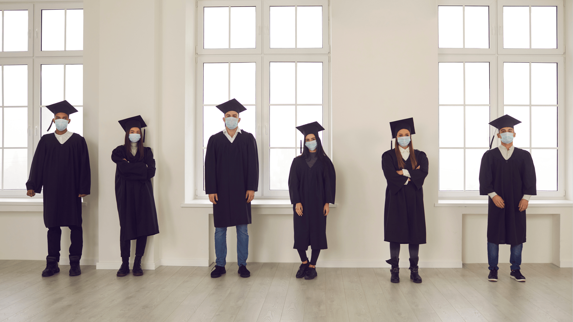Image showing people in graduation gowns and caps, wearing masks