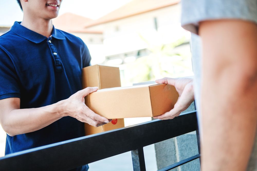 A Delivery Man is Handing a Box to a Customer — A-Team Delivery Services Pty Ltd in Maitland, NSW