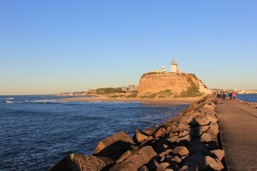 A Pier With a Lighthouse in the Background — A-Team Delivery Services Pty Ltd in Newcastle, NSW