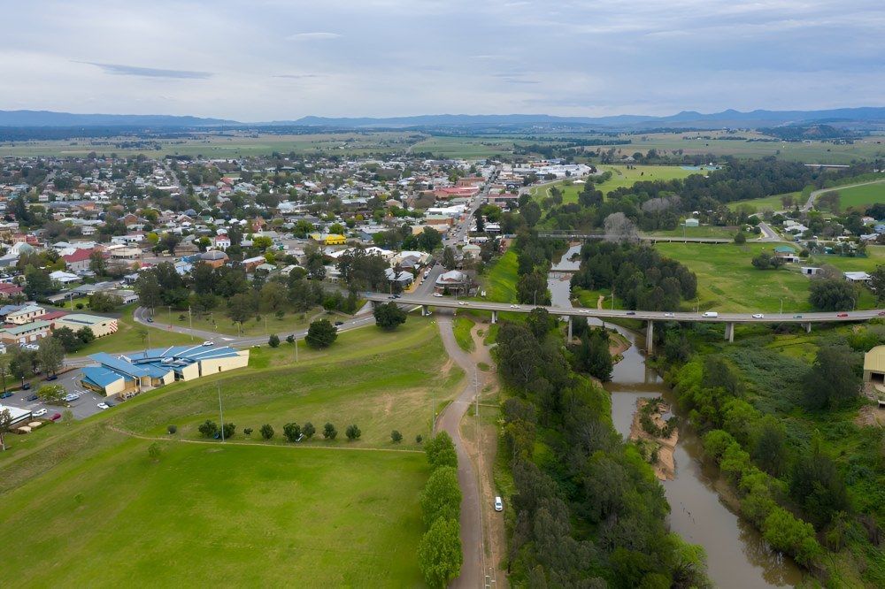 An Aerial View of a Small Town Next to a River and a Bridge — A-Team Delivery Services Pty Ltd in Singleton, NSW