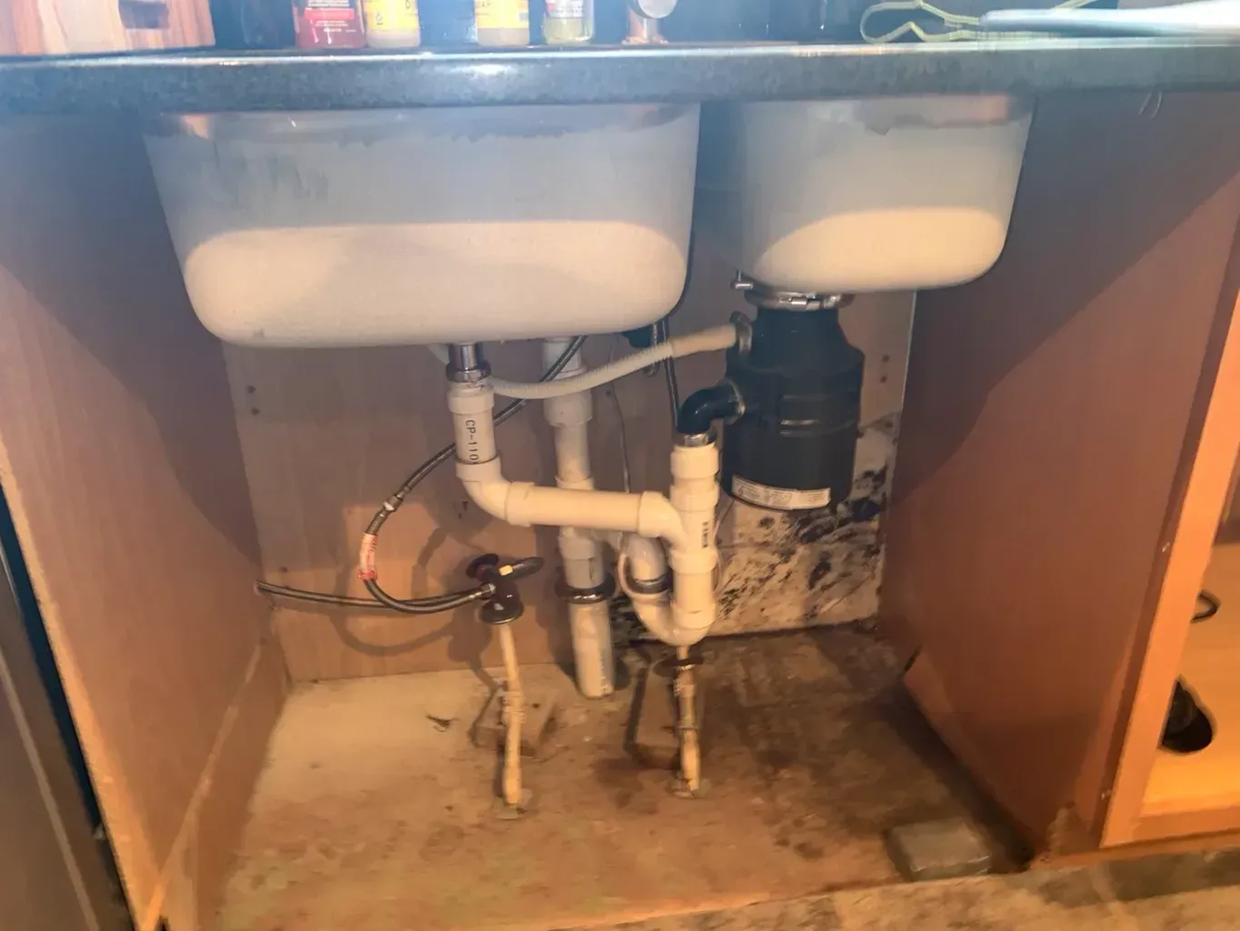 A kitchen sink with a garbage disposal underneath it.