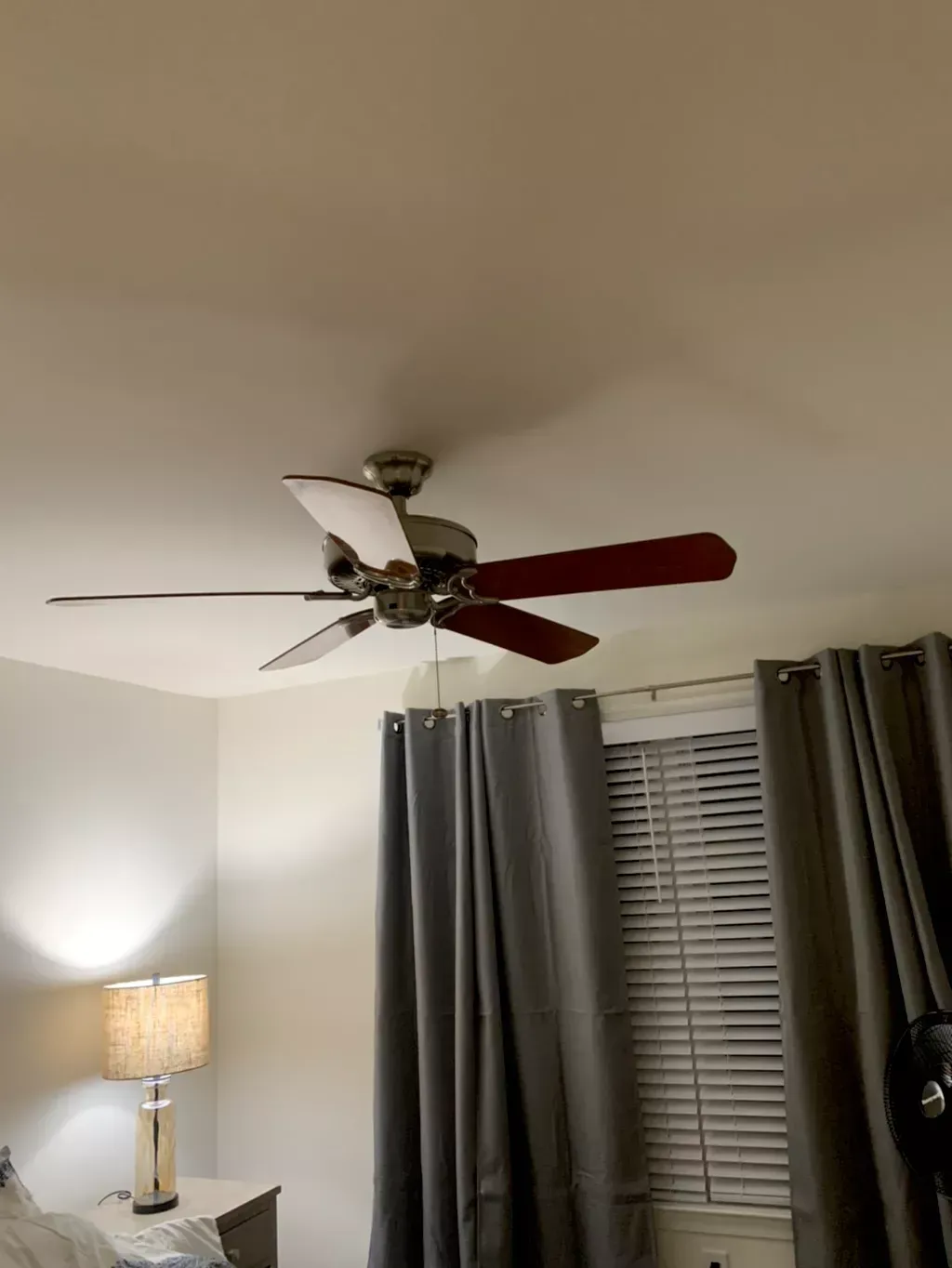 A ceiling fan is hanging from the ceiling in a bedroom.