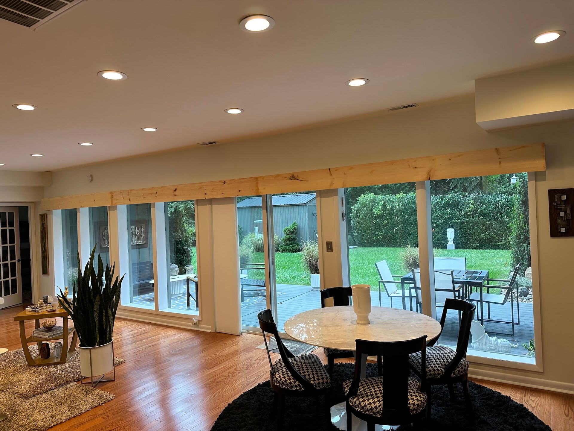 A living room with a table and chairs and a lot of windows