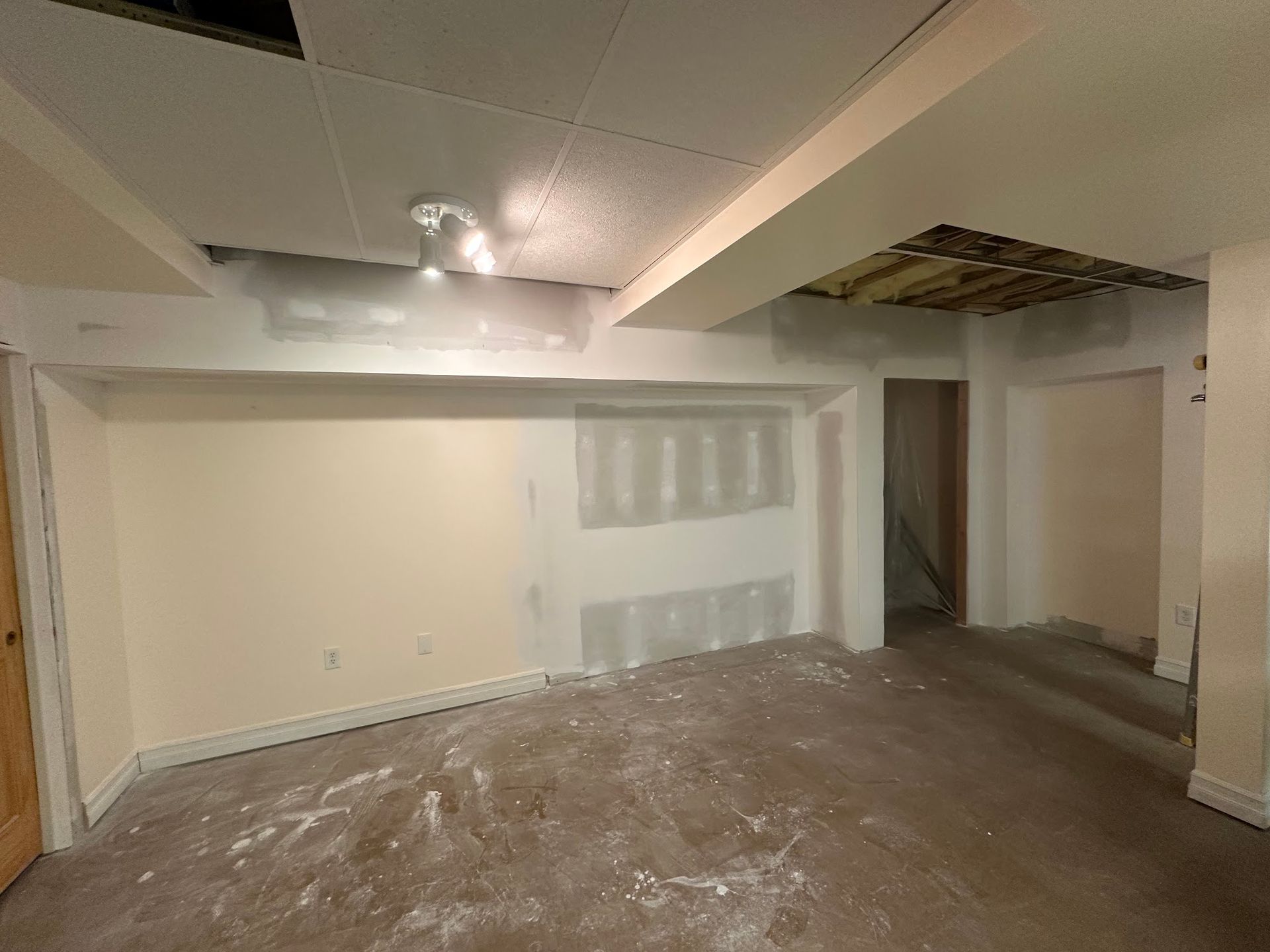 An empty room with a ceiling that is missing a piece of drywall.