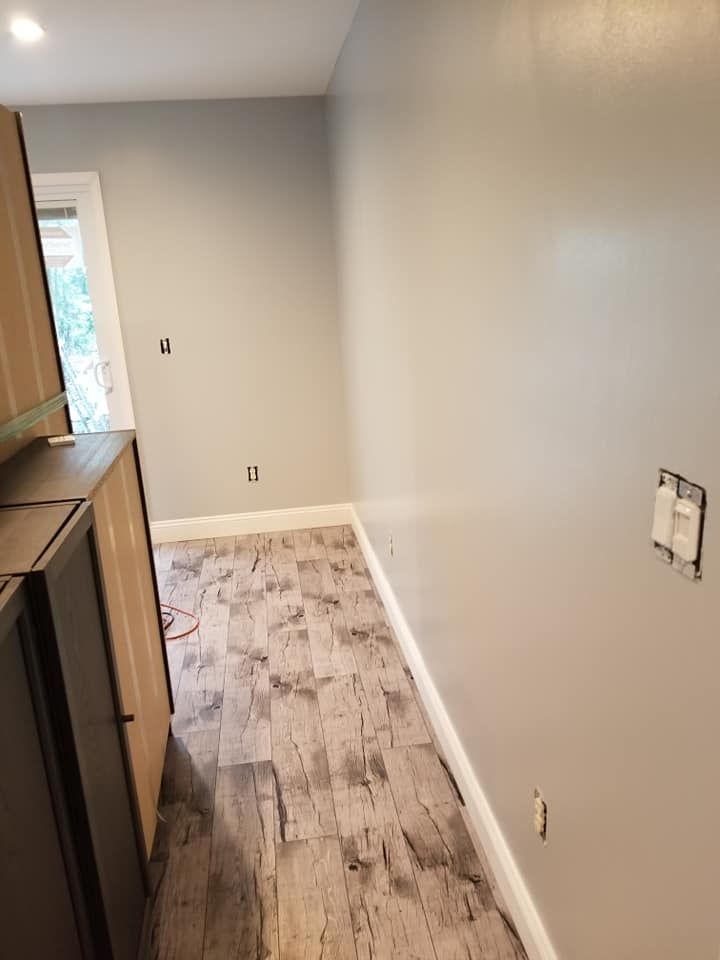 A kitchen with gray walls and a wooden floor.