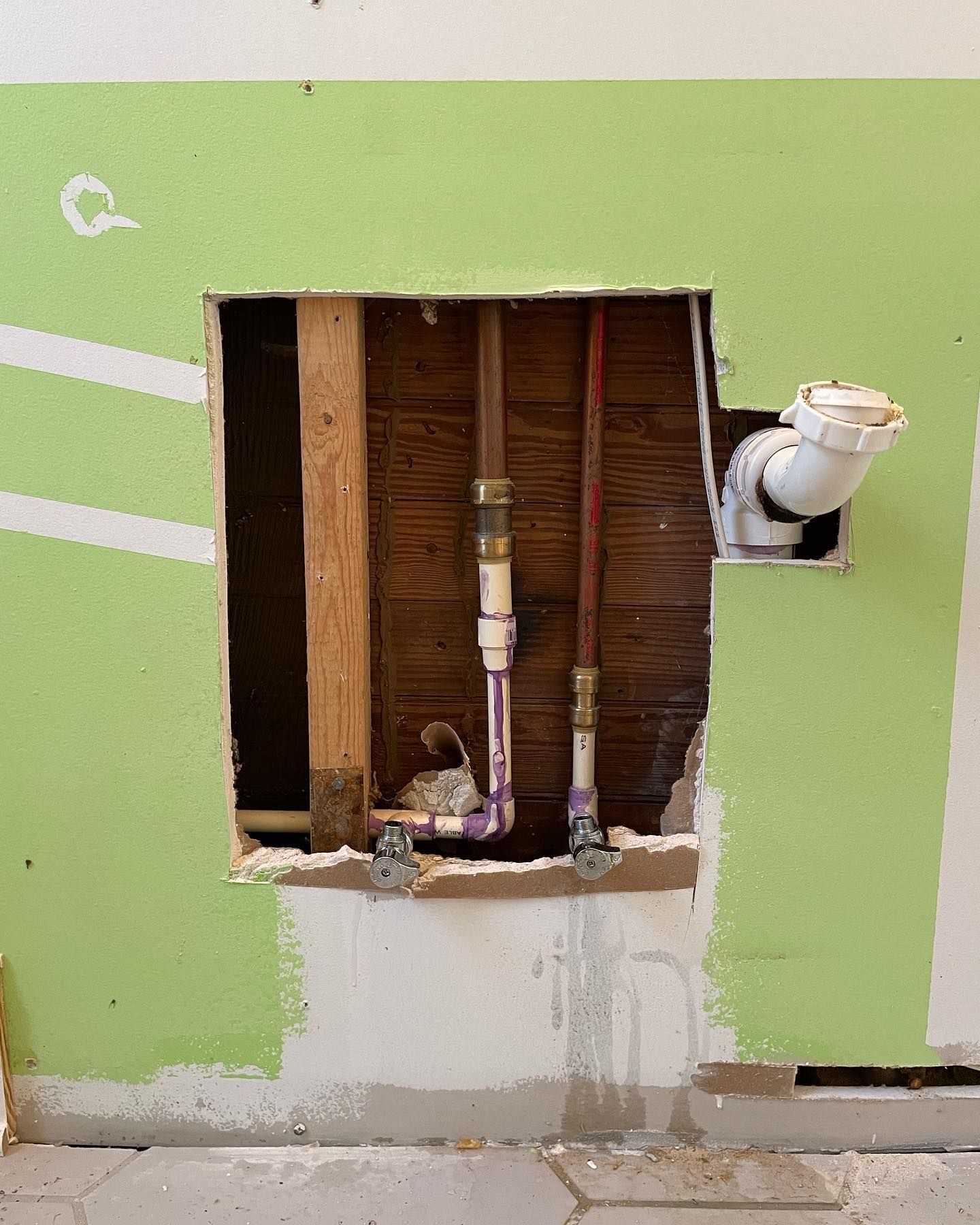 A hole in a wall with pipes coming out of it