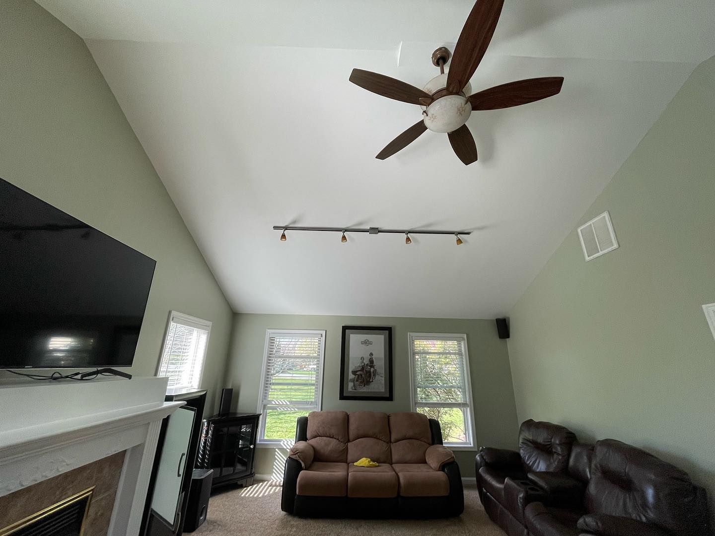 A living room with a ceiling fan and a couch.