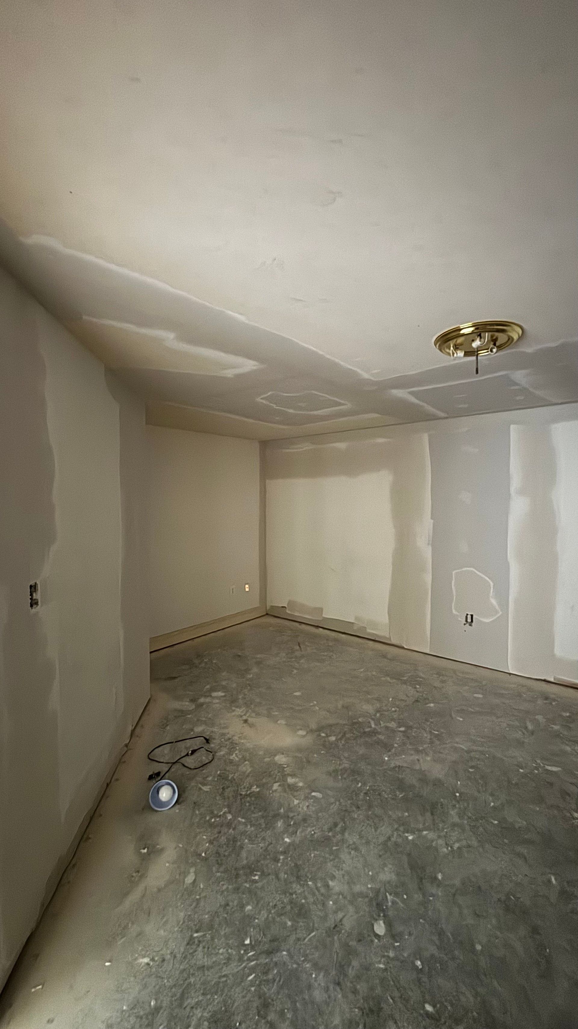 An empty room with drywall on the walls and a ceiling.