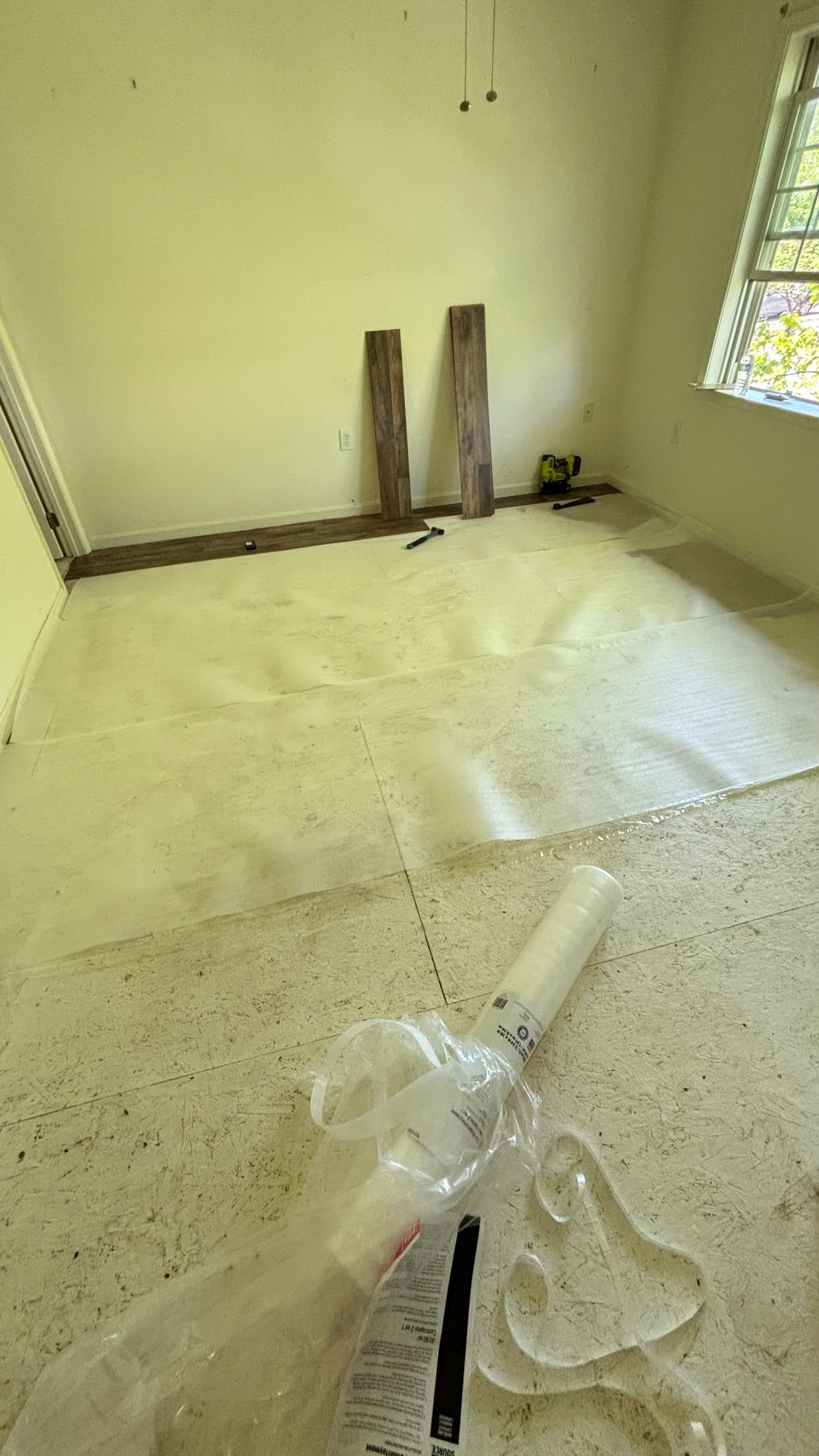 An empty room with a carpeted floor and a window.