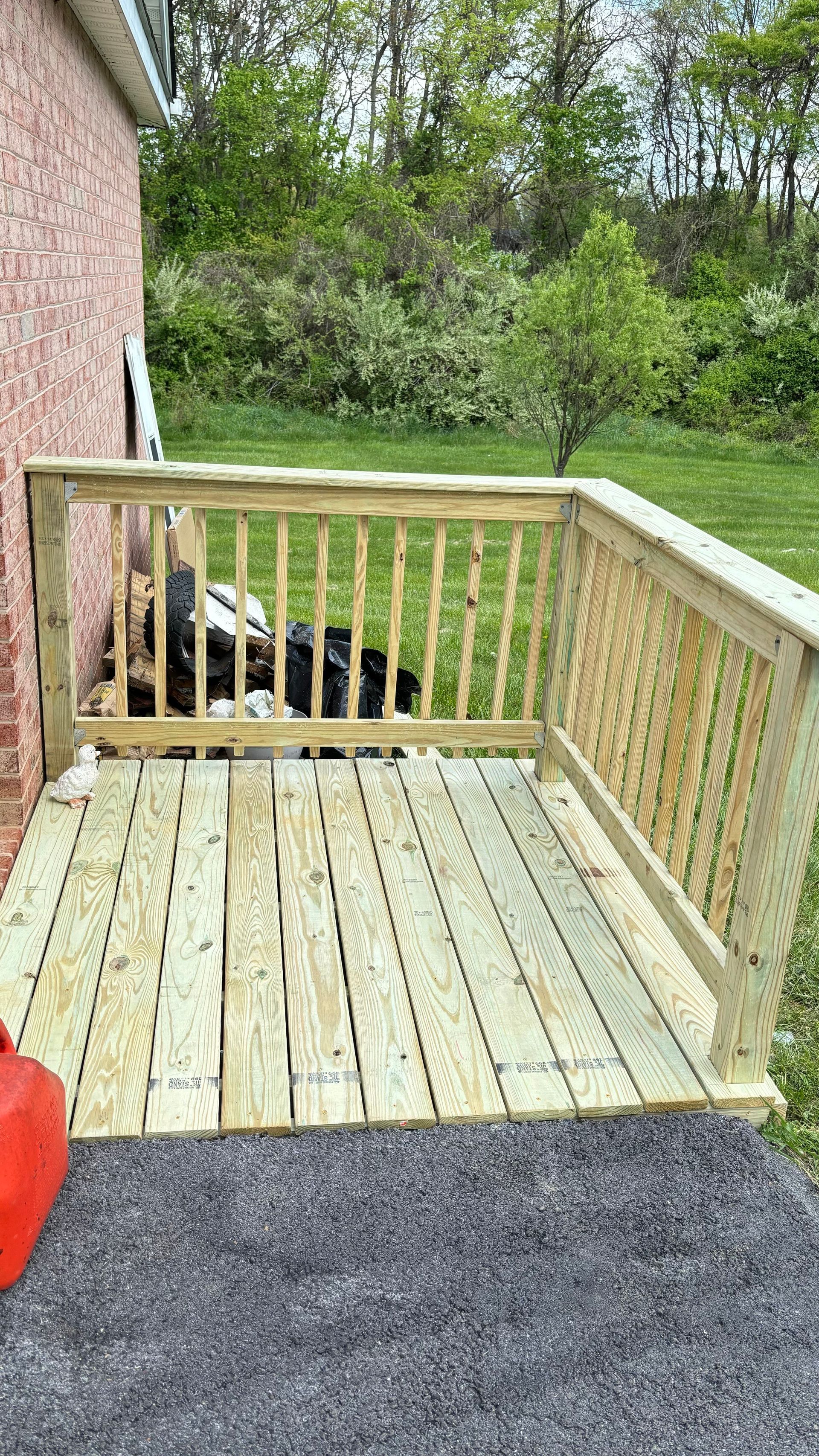 A wooden deck is being built next to a brick building.