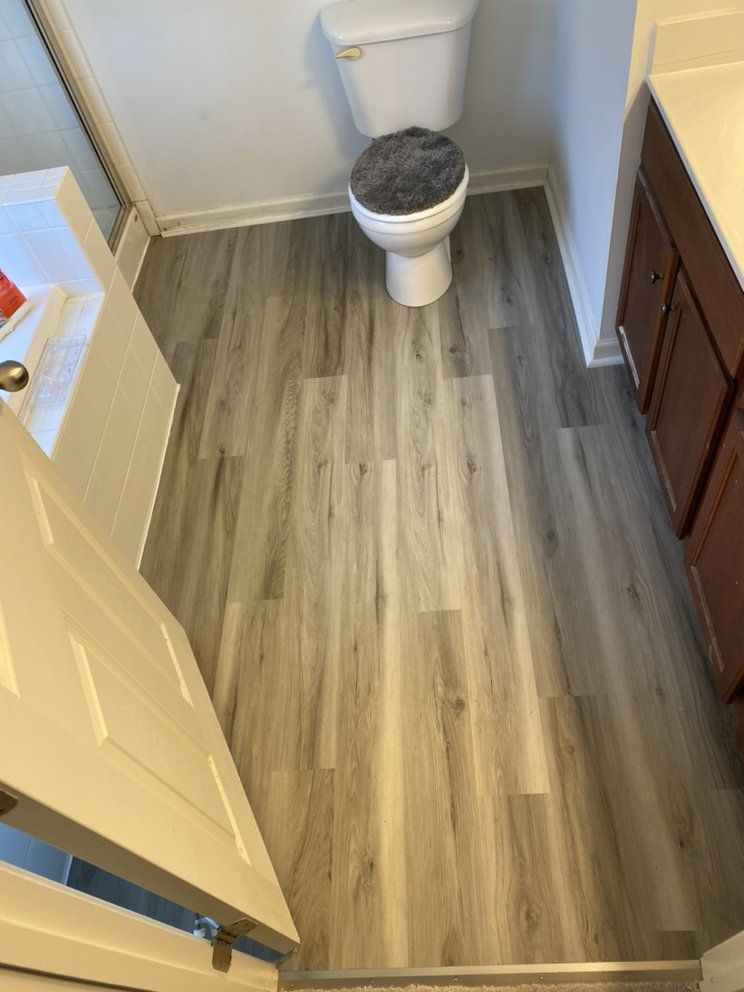 A bathroom with hardwood floors and a toilet.