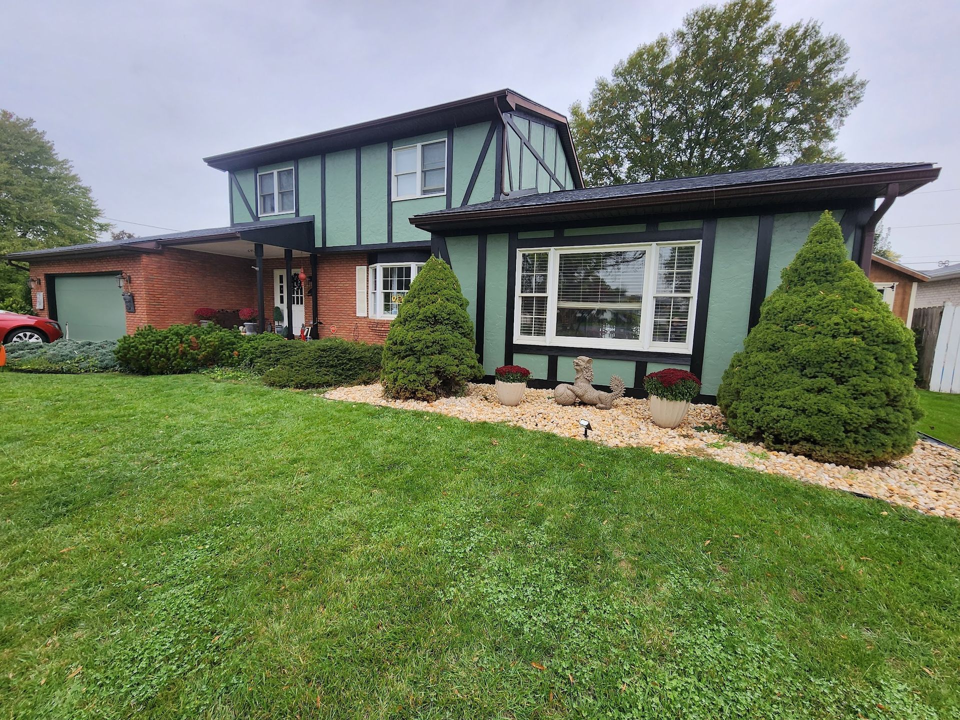 A house with a lot of windows and a large lawn in front of it.