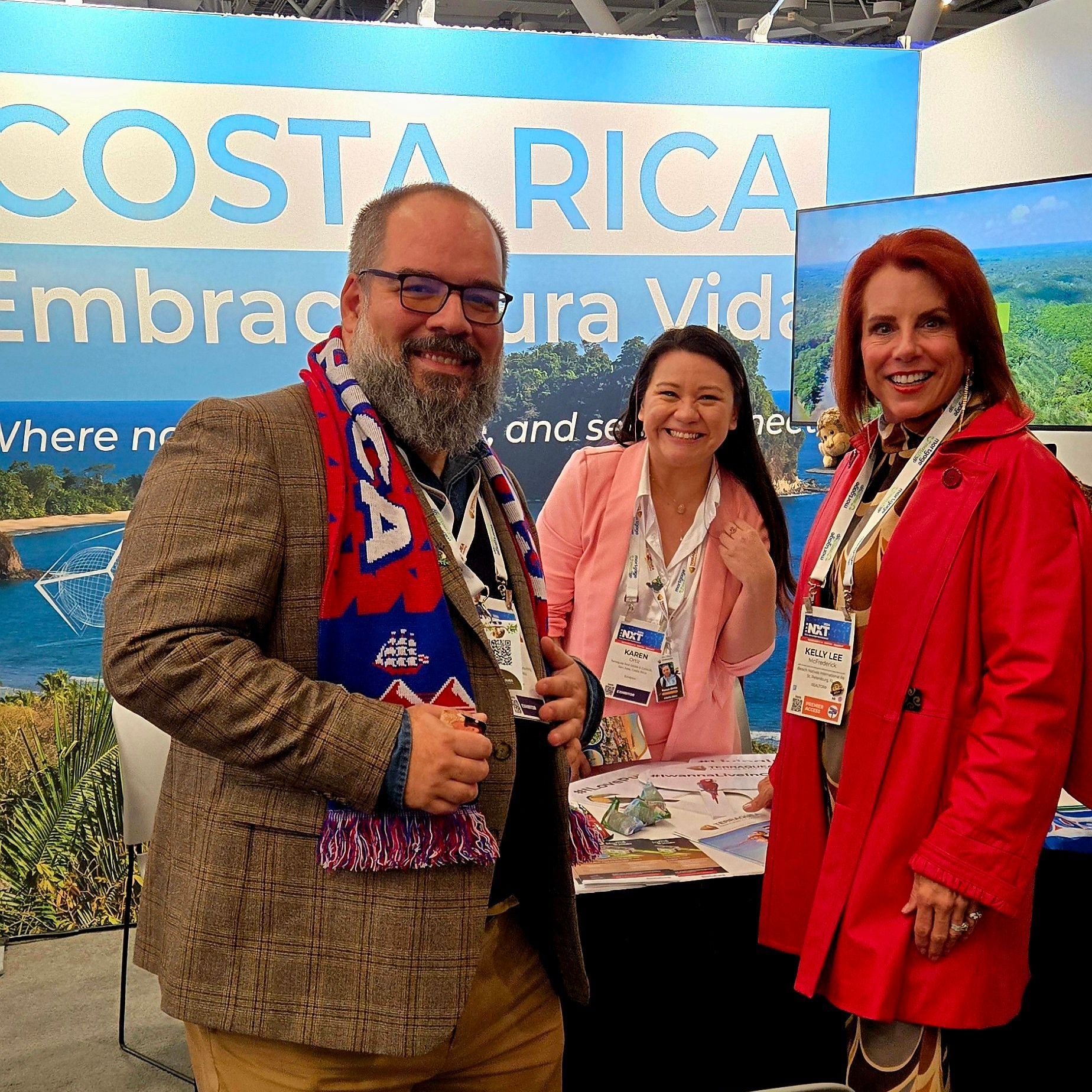 Three people standing in front of a costa rica sign