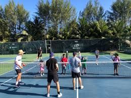 A group of people are playing tennis on a tennis court.