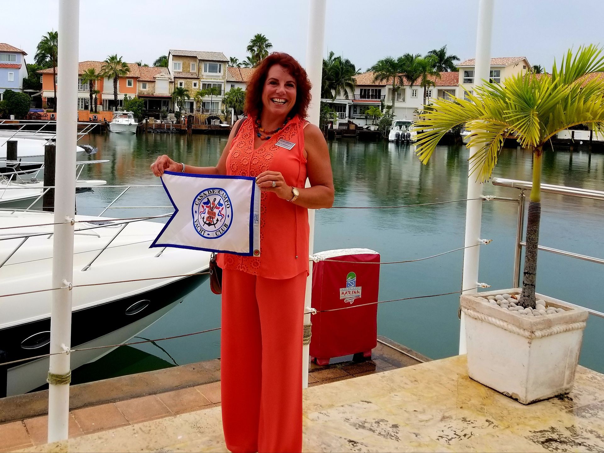 A woman is holding a flag in front of a boat
