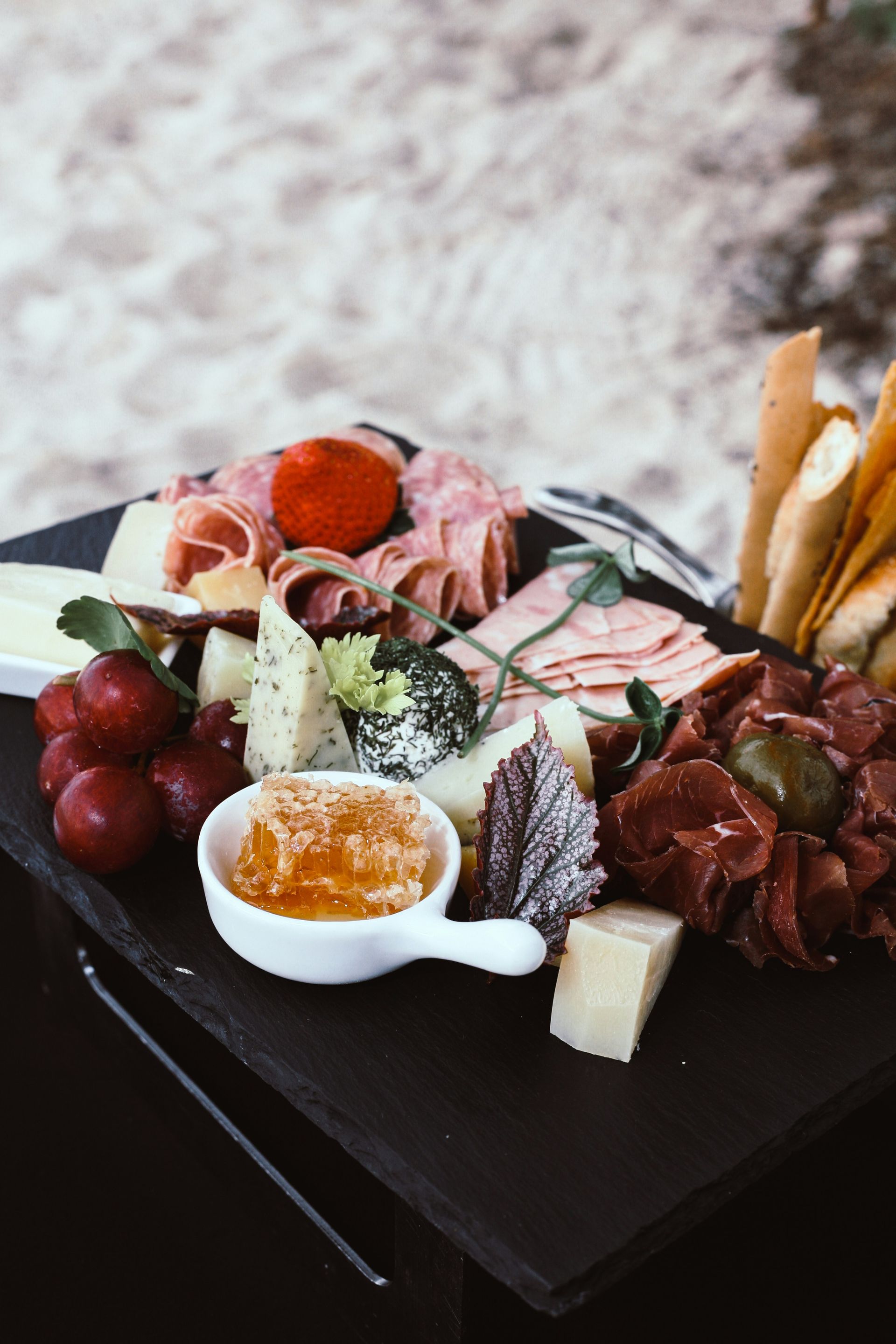 There is a plate of food on the table with a bowl of honey.
