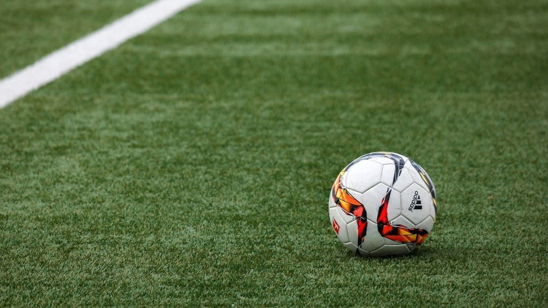 A soccer ball is sitting on top of a soccer field.