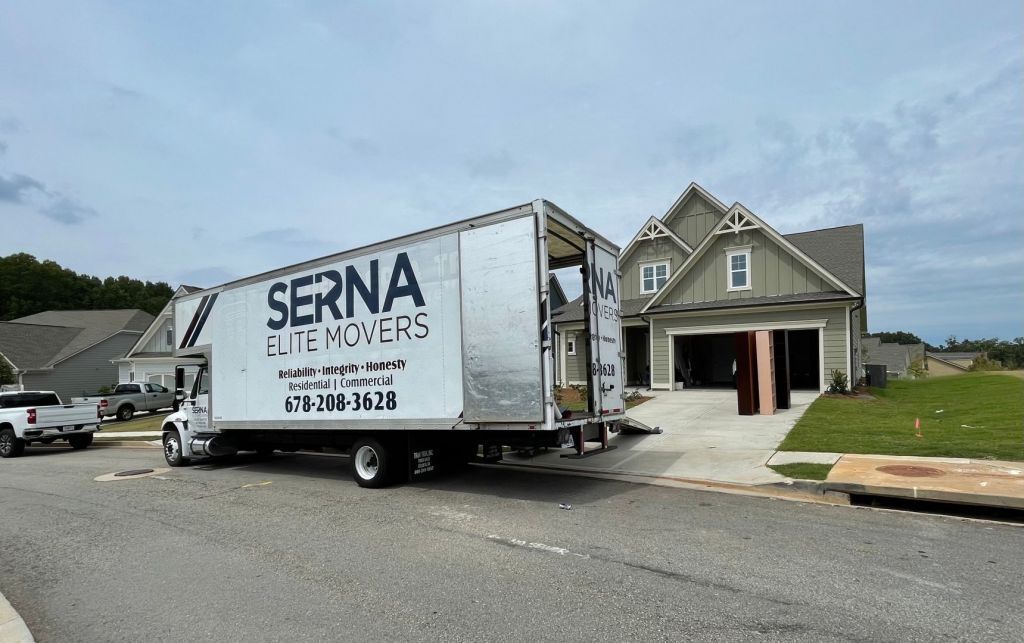 A serna moving truck is parked in front of a house.