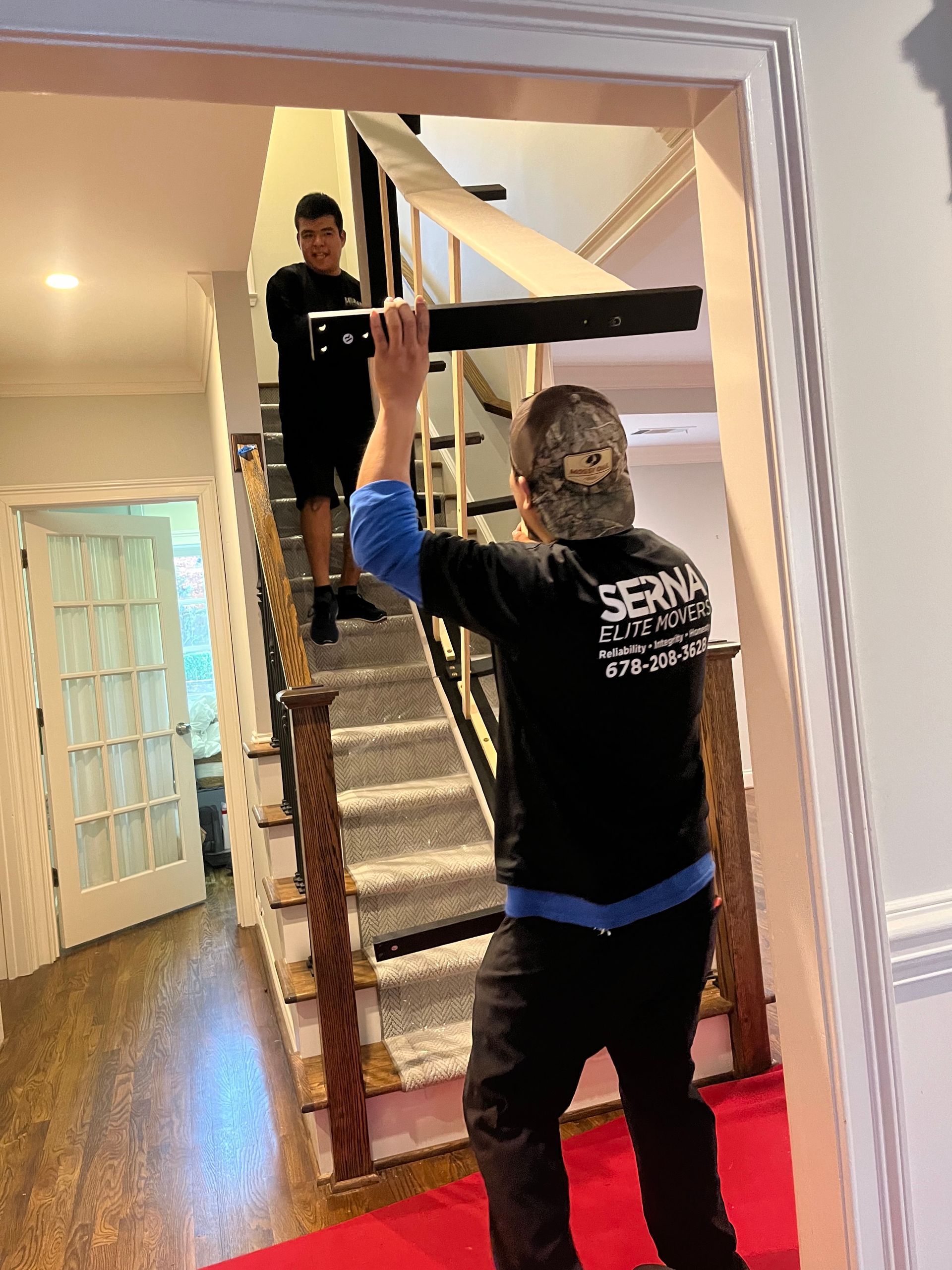 A man is carrying a piece of wood up a set of stairs.