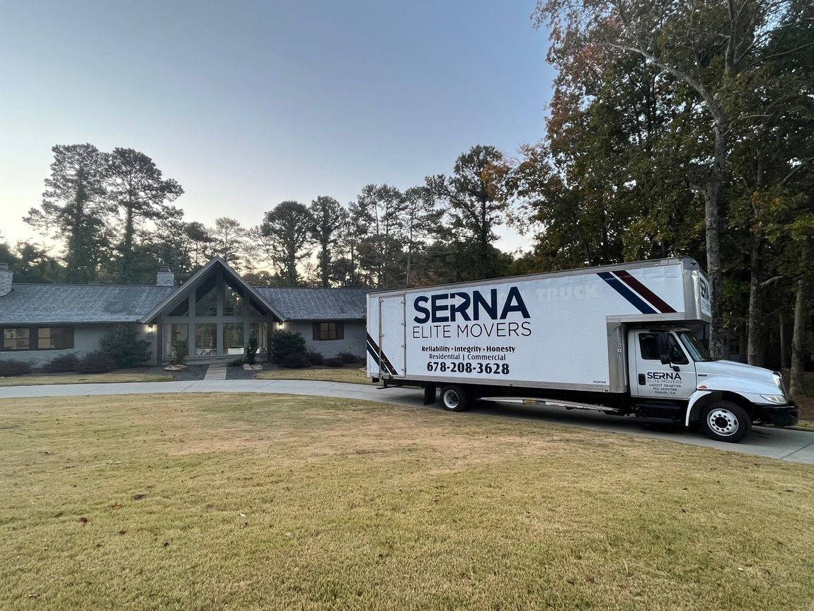 A moving truck is parked in front of a house.