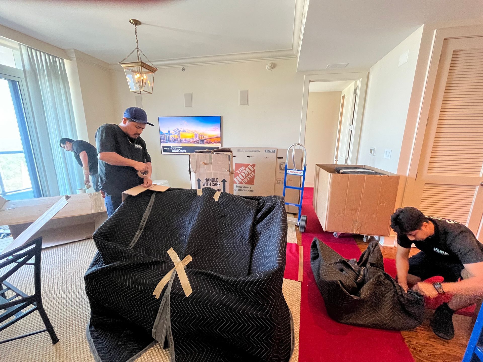A group of men are moving a couch in a living room.