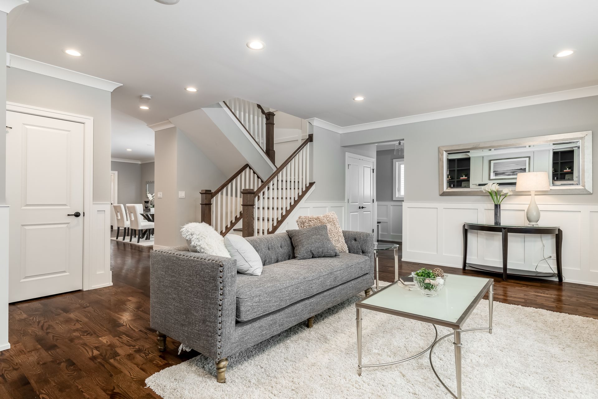 A living room with a couch , coffee table , and stairs.