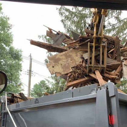 A pile of wood is sitting on top of a dumpster.