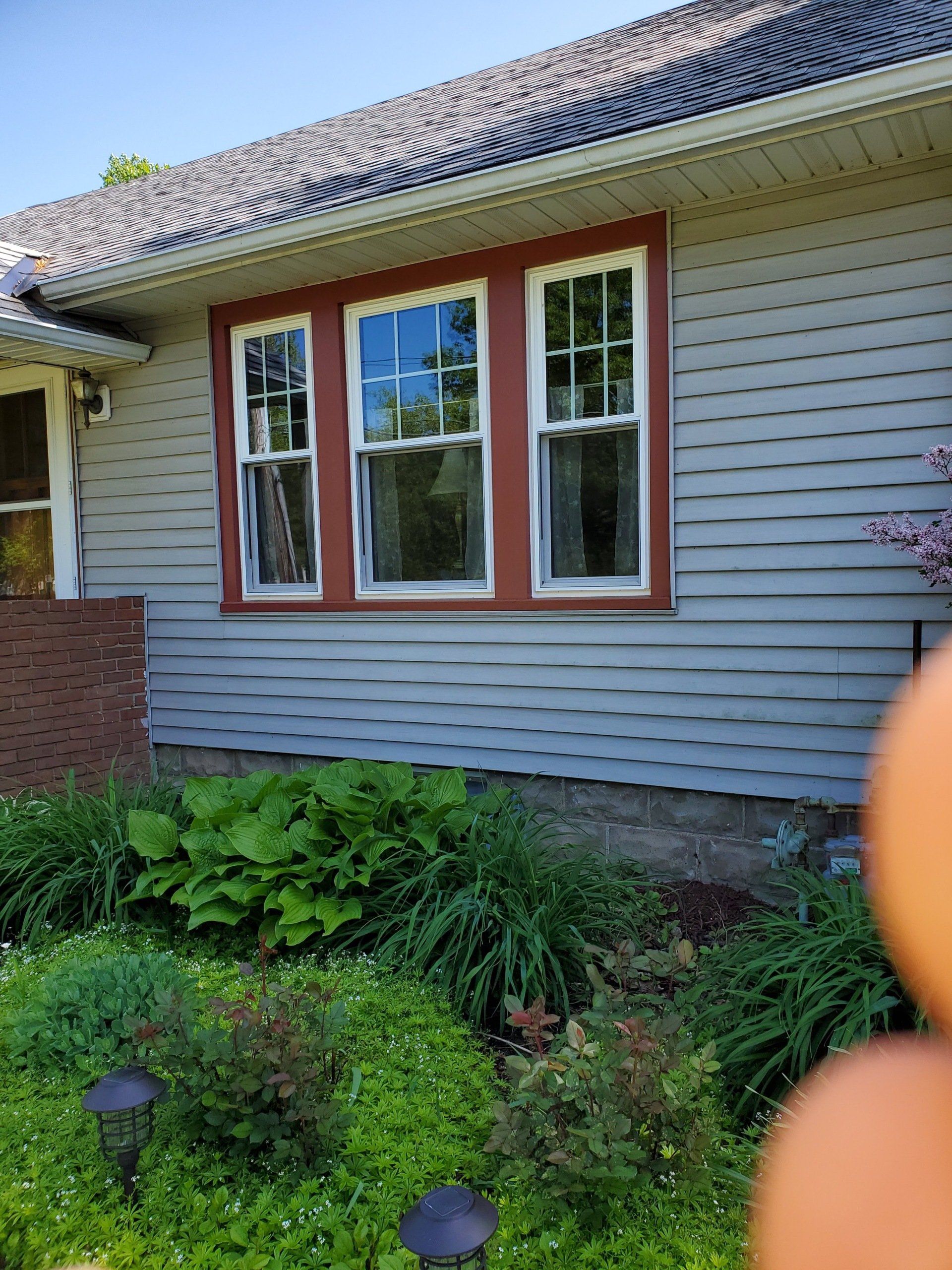 A house with a lot of windows and a garden in front of it.