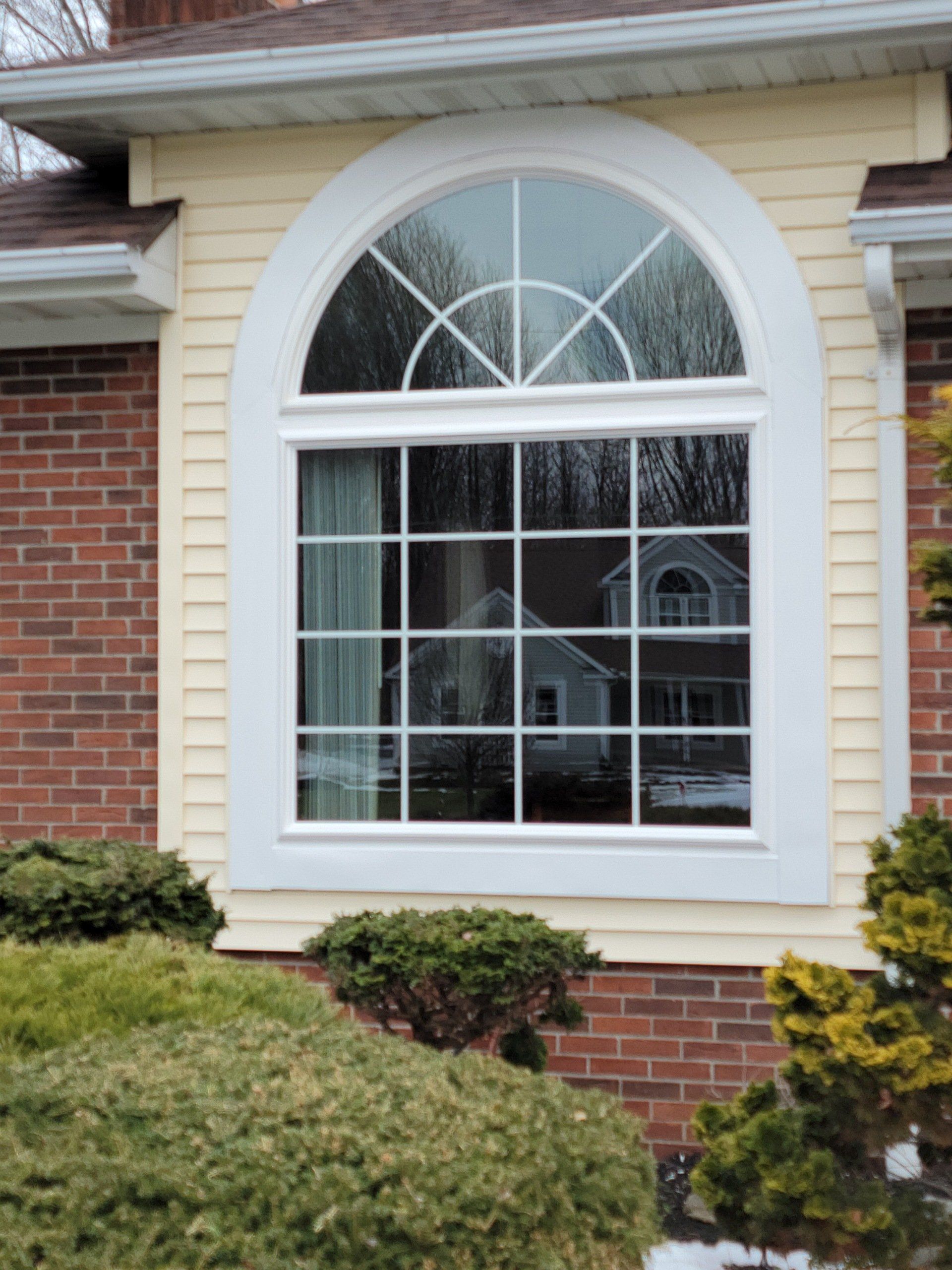 A large window on the side of a brick house