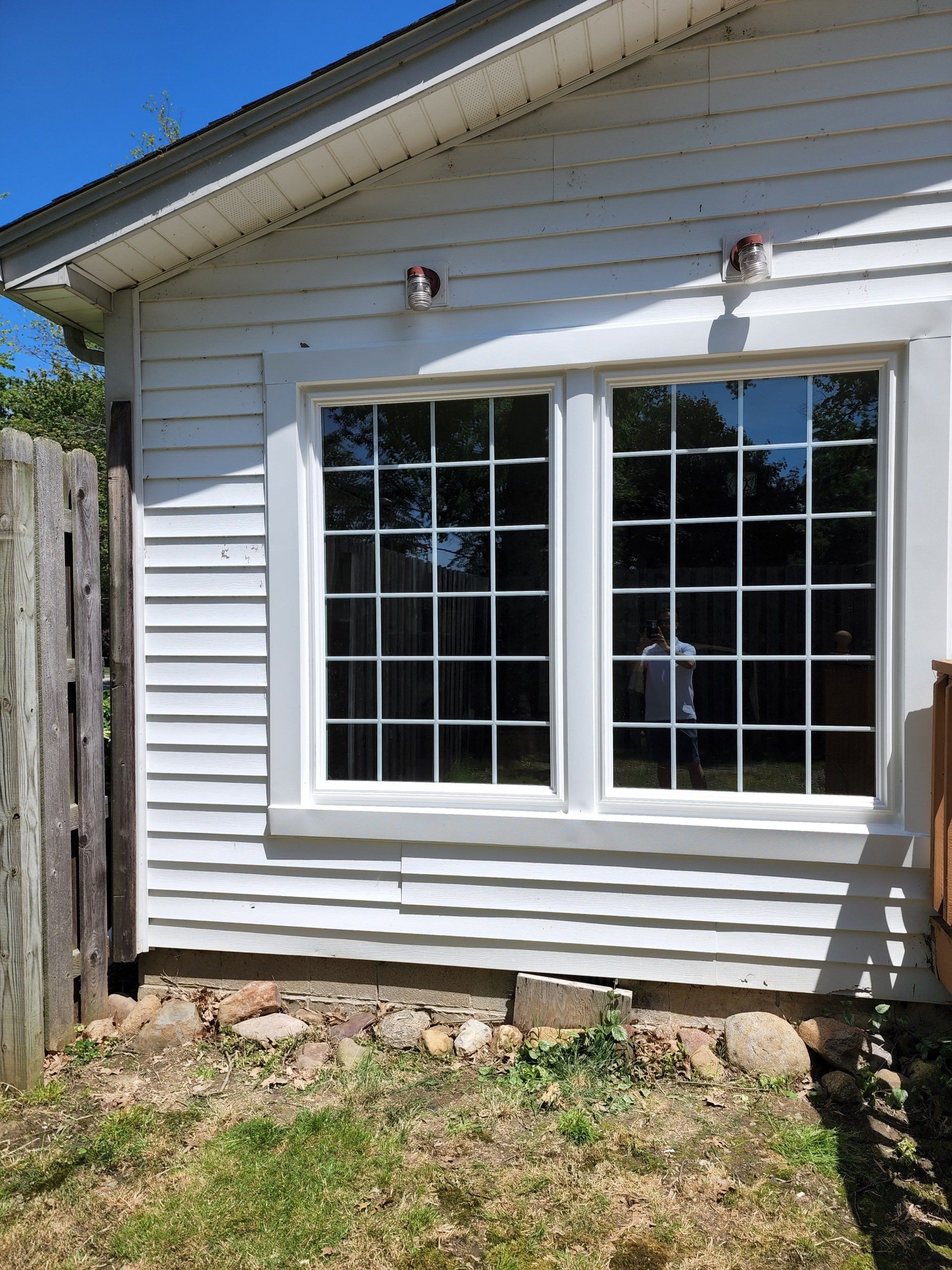 A white house with a lot of windows and a wooden fence