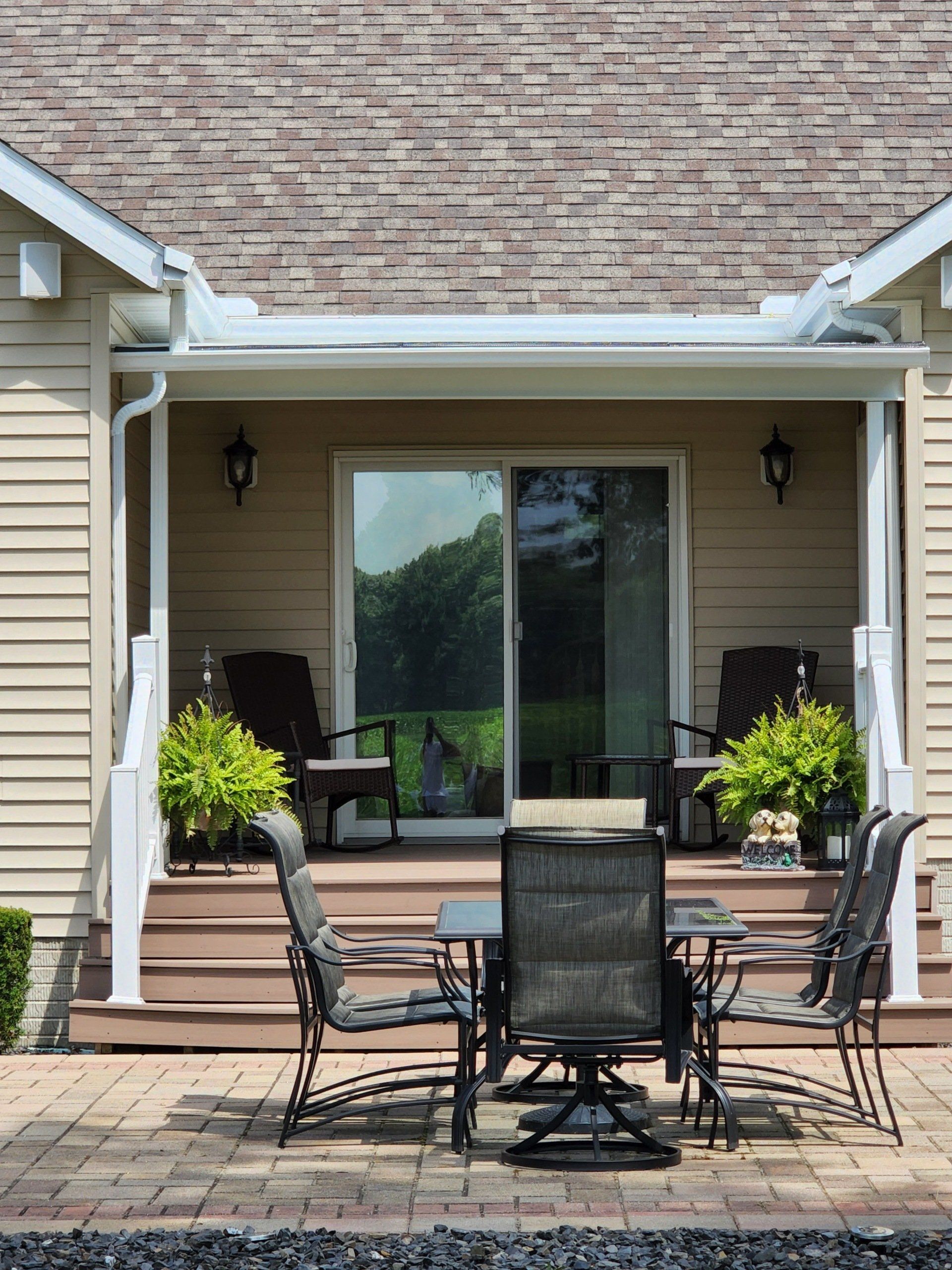 A patio with a table and chairs in front of a house