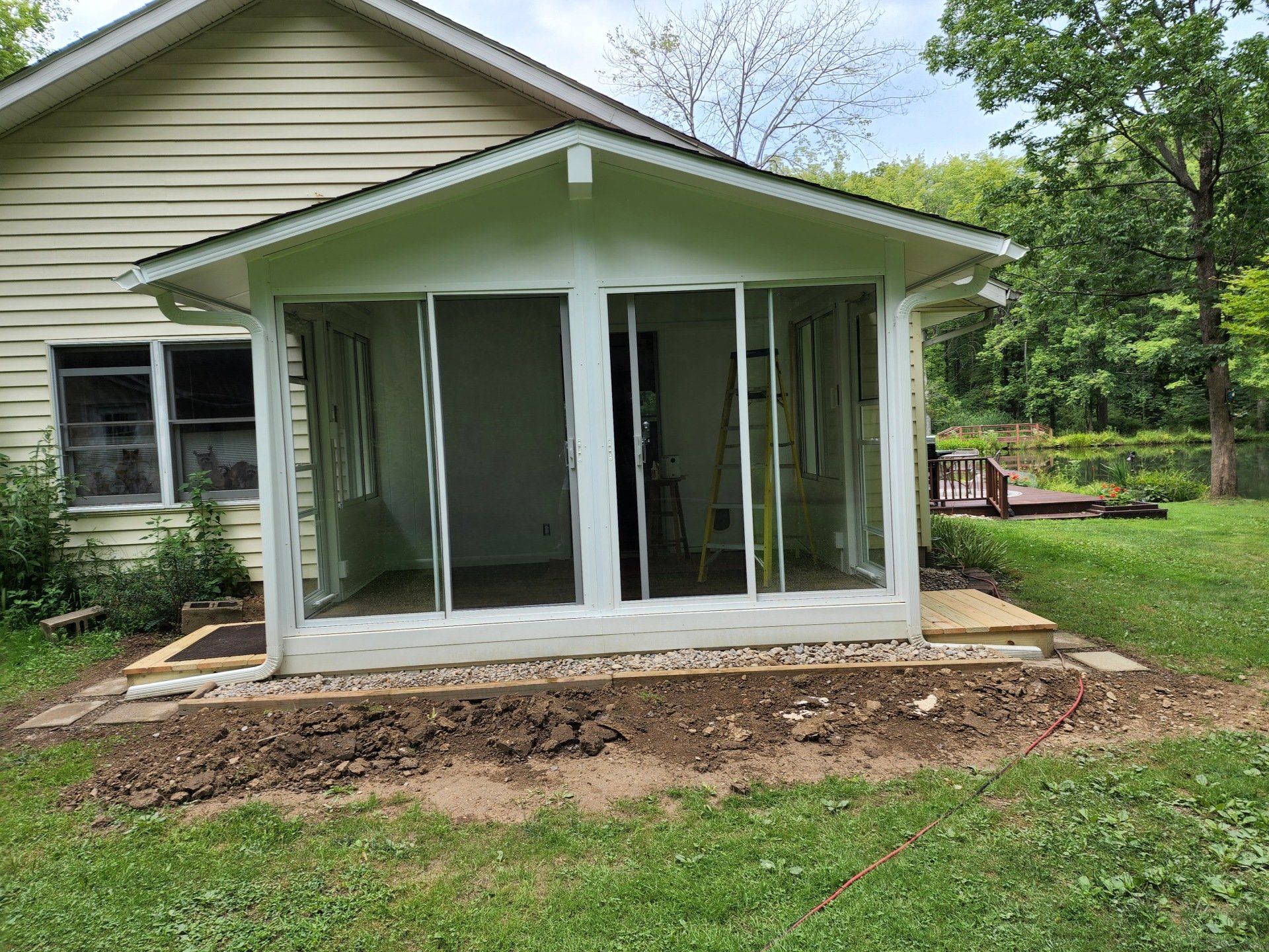 A house with a screened in porch and sliding glass doors.