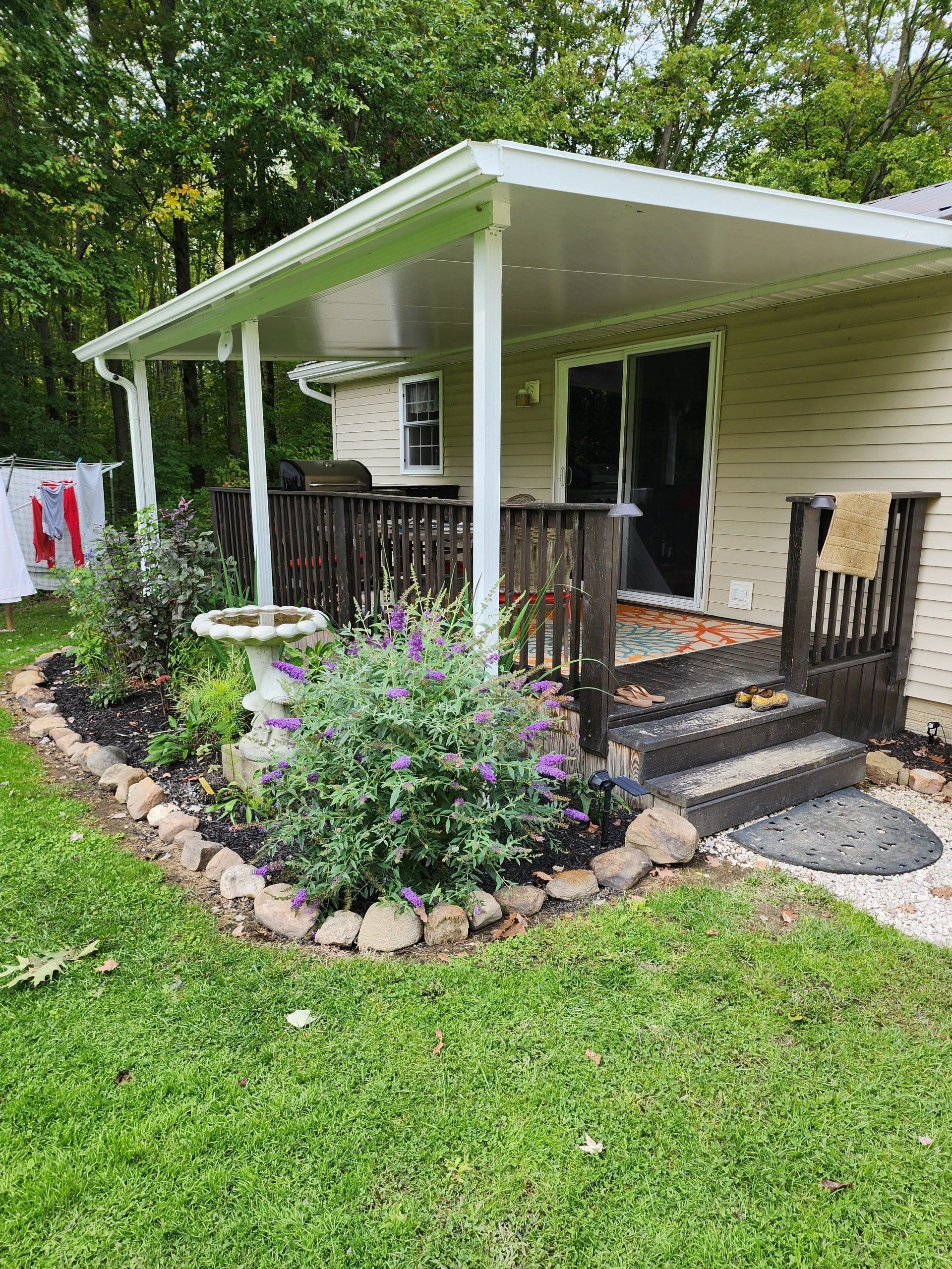 A small house with a porch and stairs in the backyard.