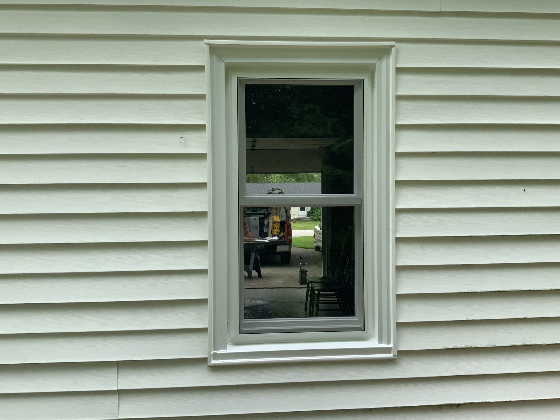 A white house with a window on the side of it.