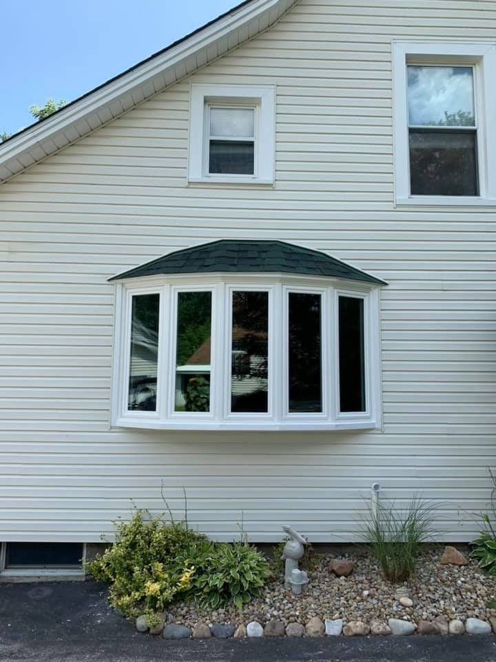 A white house with a large bay window on the side of it.