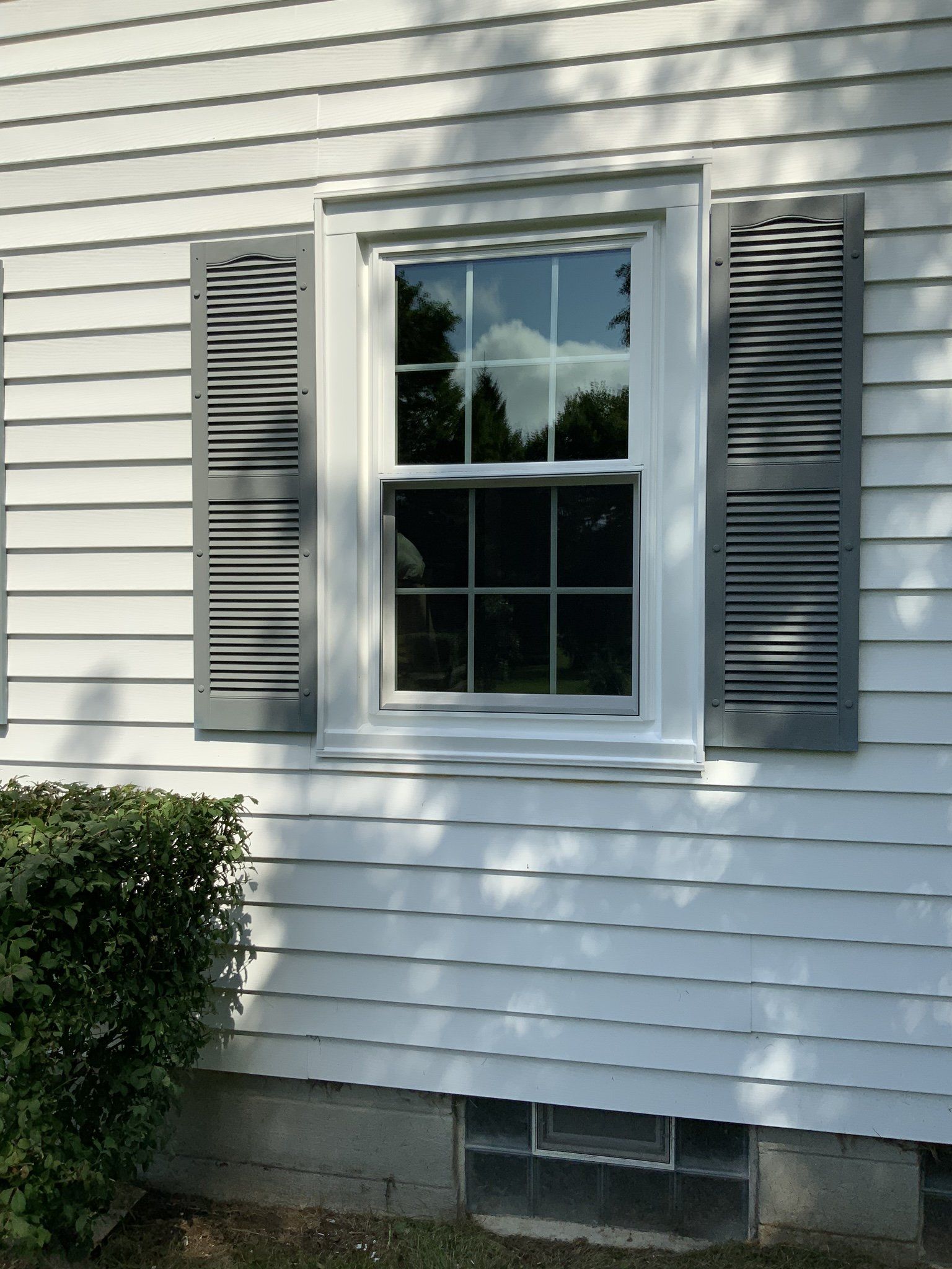 A white house with a window and shutters on it