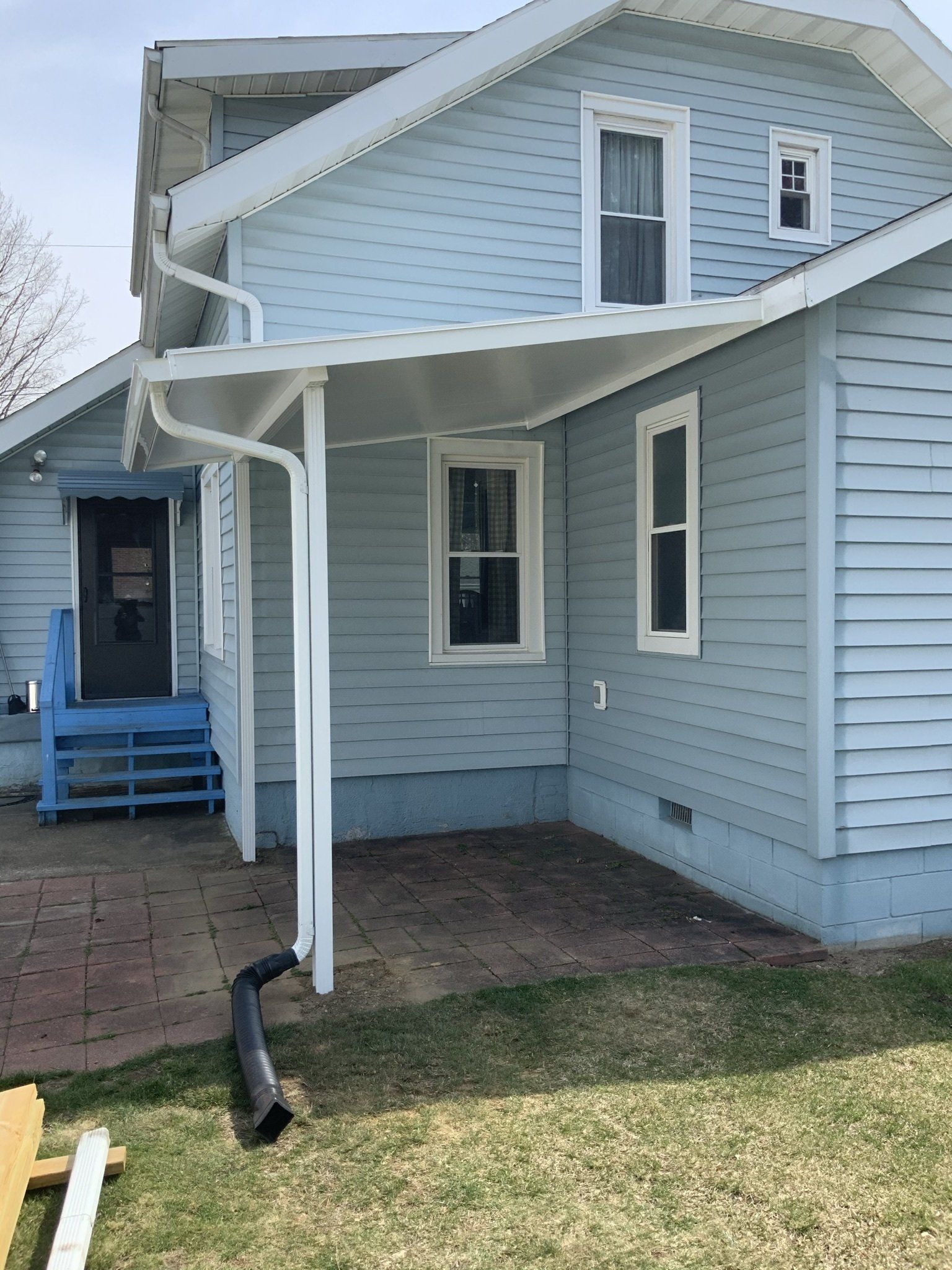 A blue house with a white awning over the porch.